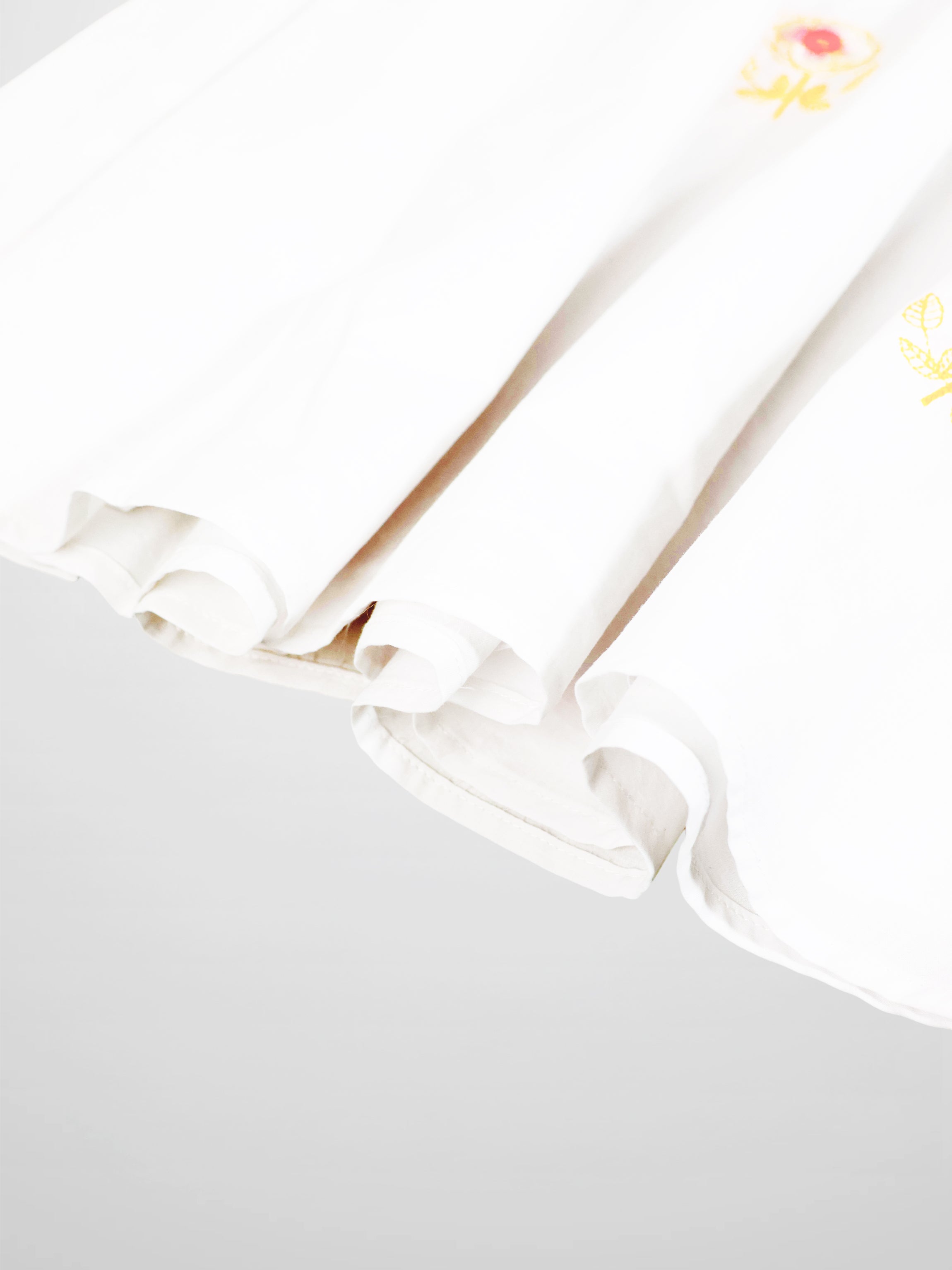 Embroidered Flower Skirt for girls, white dressy skirt with yellow floral embroidery along the edge.
