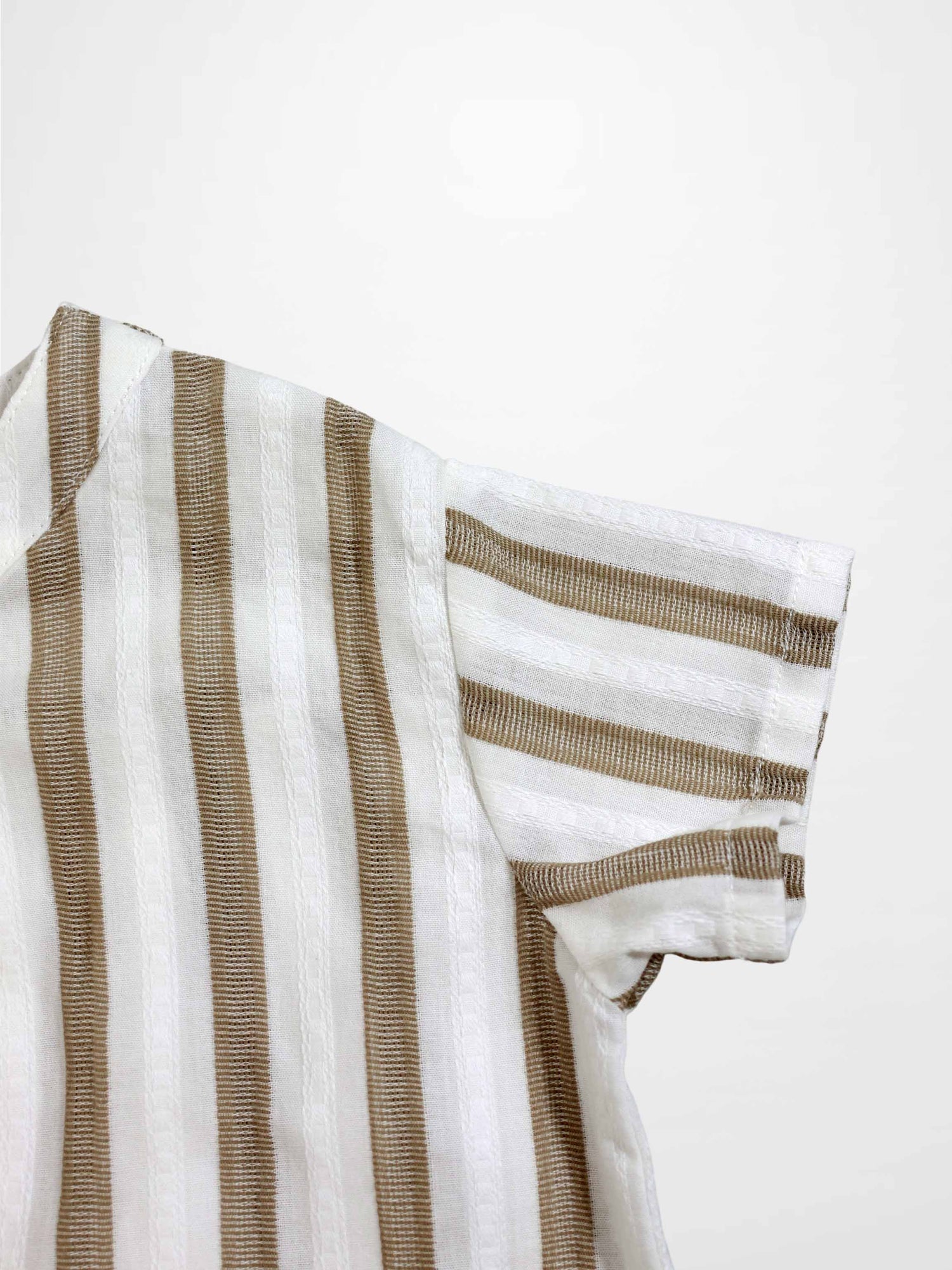 Tan and white striped romper fabric with a short sleeve close-up.