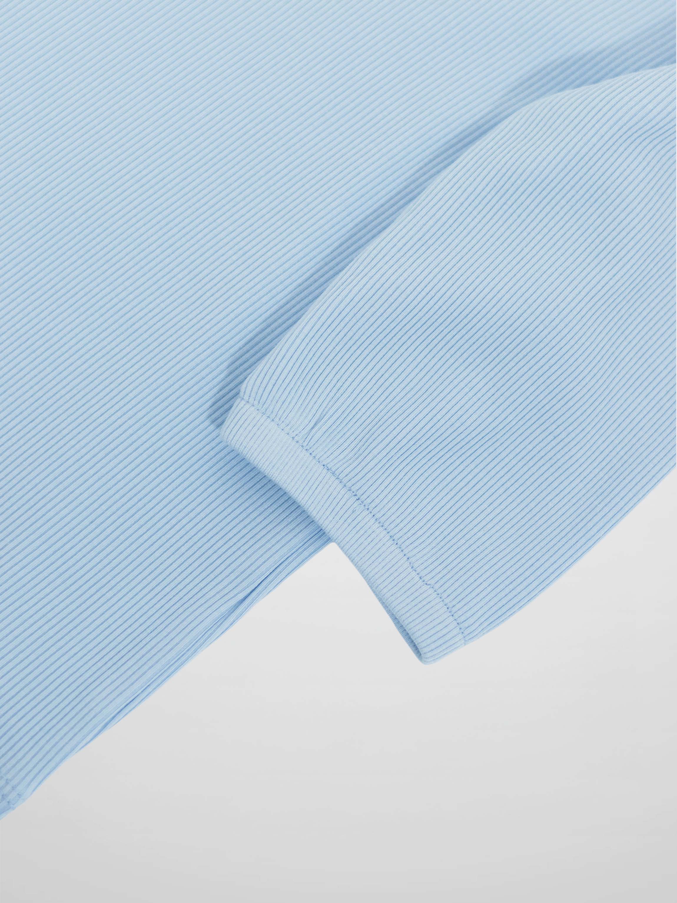 Close-up of light blue pinstripe 3/4 puff sleeve cuff on a T-shirt.