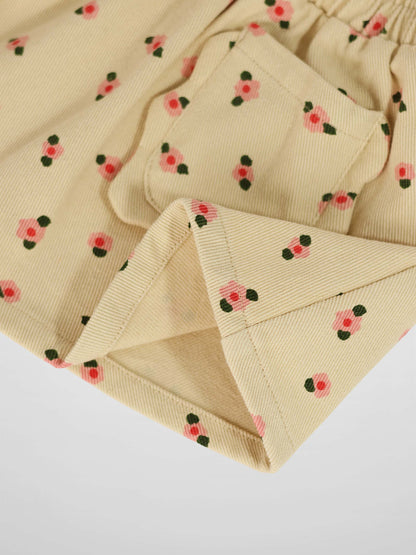 Tan corduroy skirt with tiny pink flowers and dark green leaves.