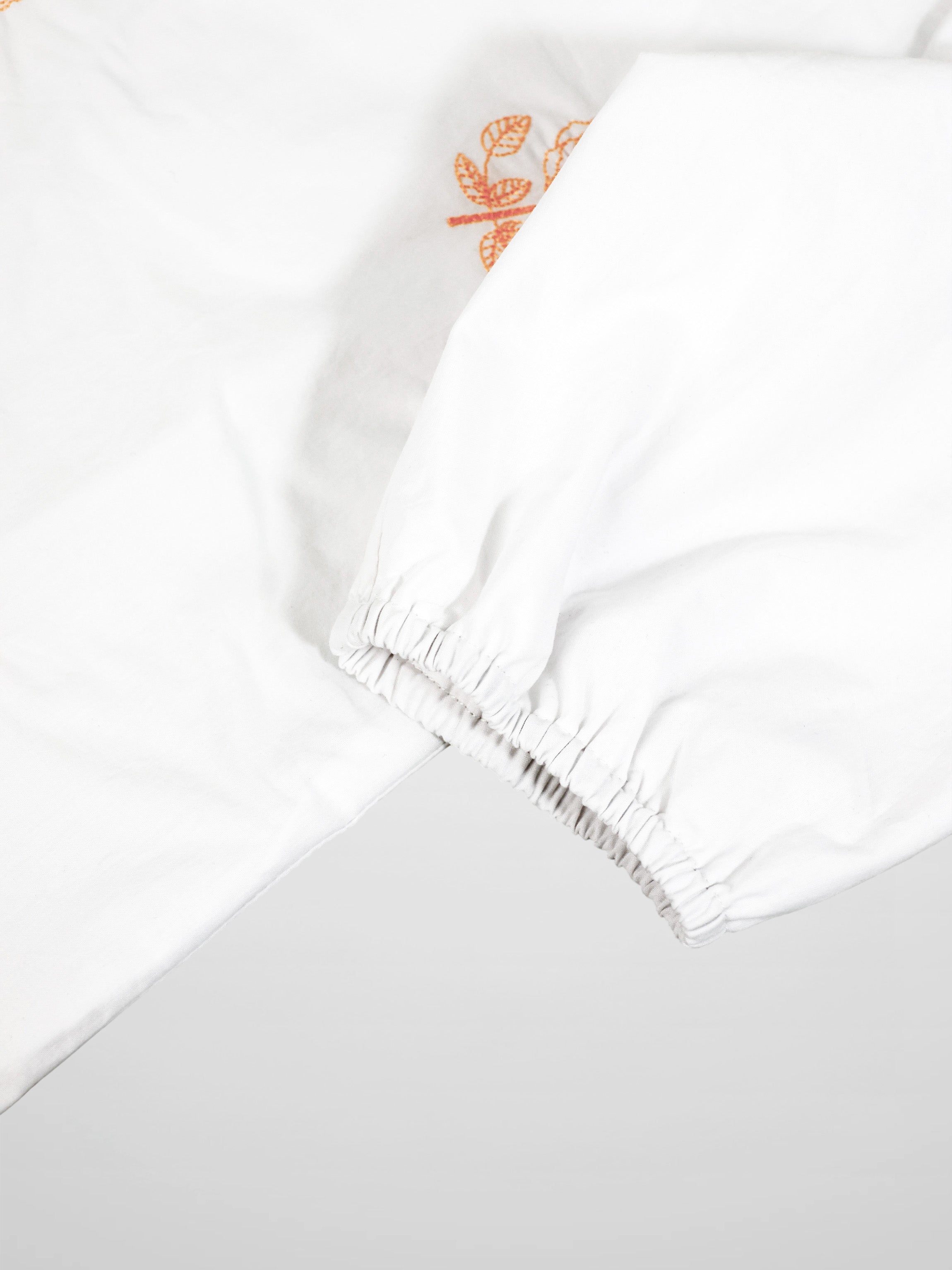 Embroidered Flower Shirt by Adee; white girls dressy T-shirt with orange floral embroidery and elastic cuffs.