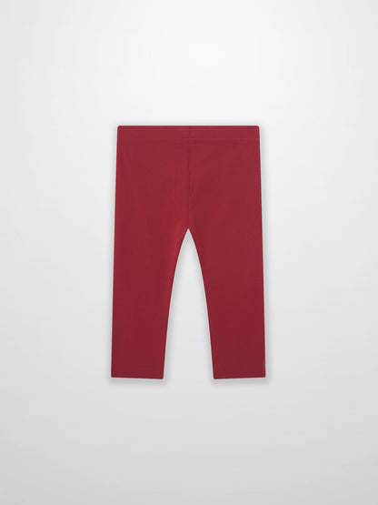 Non ribbed red leggings for unisex bottoms; plain fabric with visible waistband.