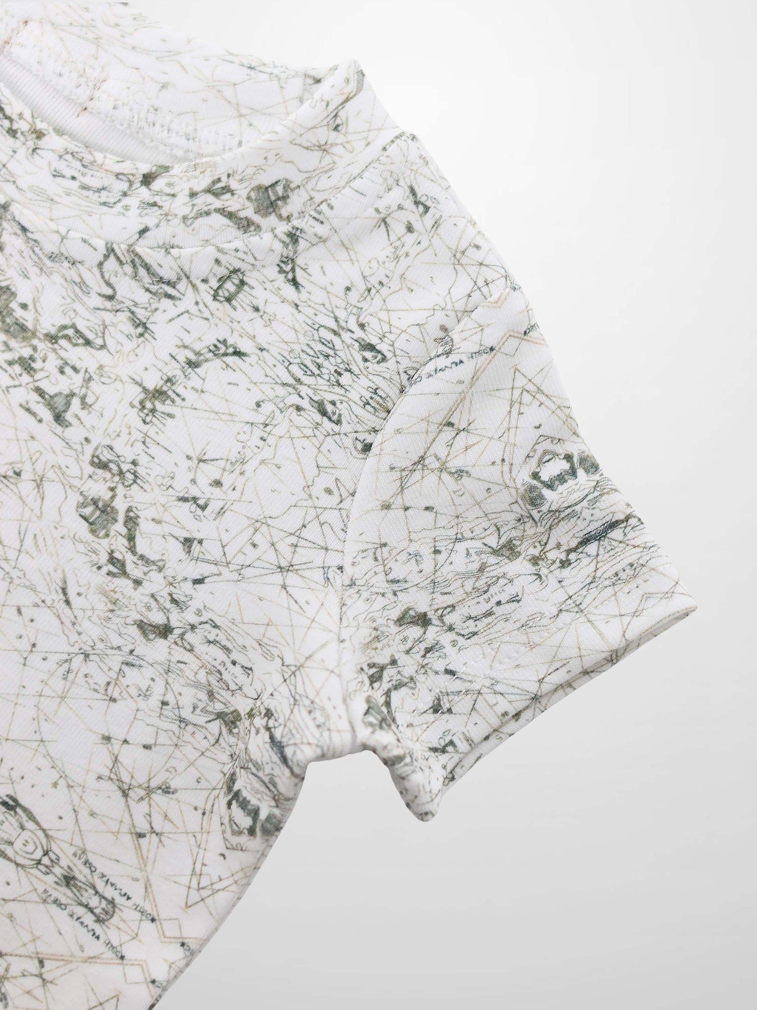 Map T-shirt with vintage sage-green map lines and compass markers on off-white fabric.