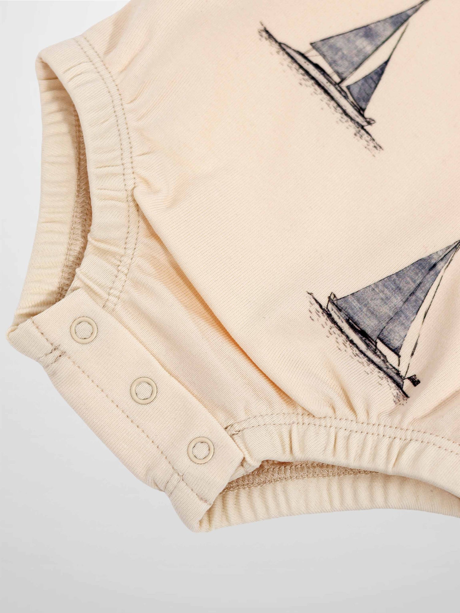 Sail Boat Romper for Boys in cream with navy sailboat print and snap closures