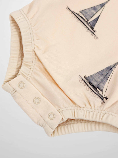 Sail Boat Romper for Boys in cream with navy sailboat print and snap closures