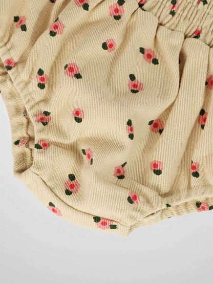 Tan floral bloomers for girls in ribbed fabric with pink flowers and green leaves, elastic waist and leg openings.