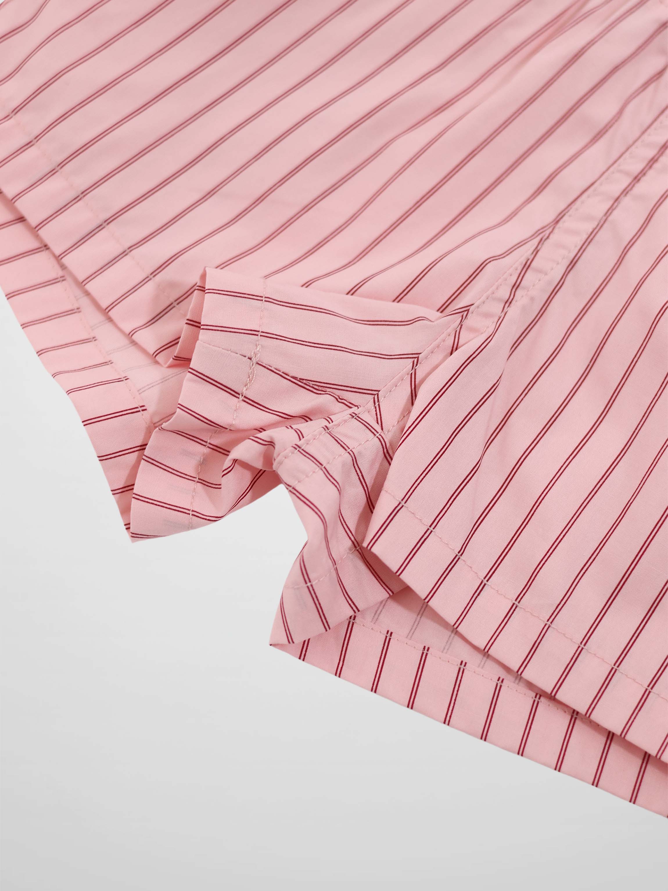 Pink striped cotton shorts with red vertical stripes, folded hem detail.