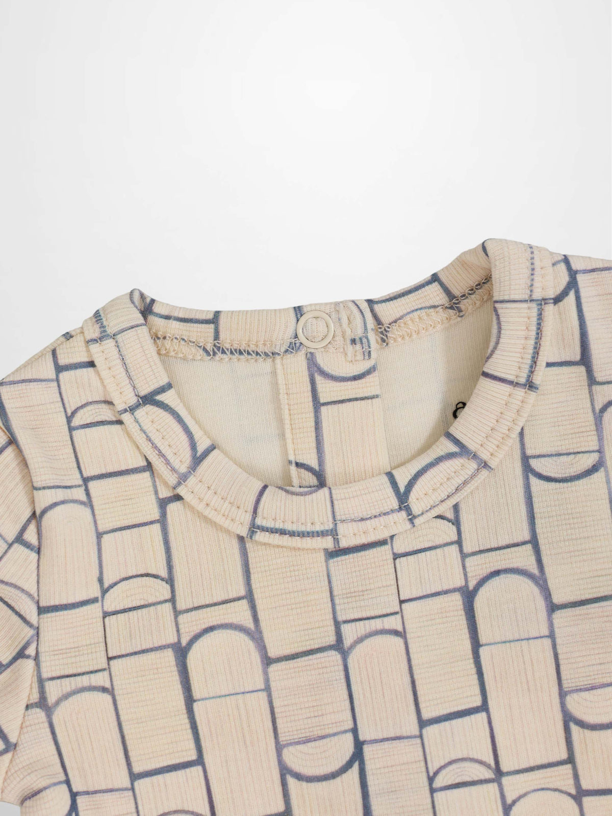 Beige baby jumpsuit with light-blue geometric pattern of rounded rectangles and arches; crossover-front design.