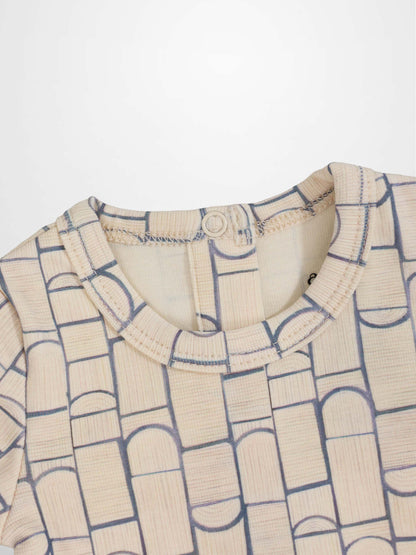 Beige baby jumpsuit with light-blue geometric pattern of rounded rectangles and arches; crossover-front design.