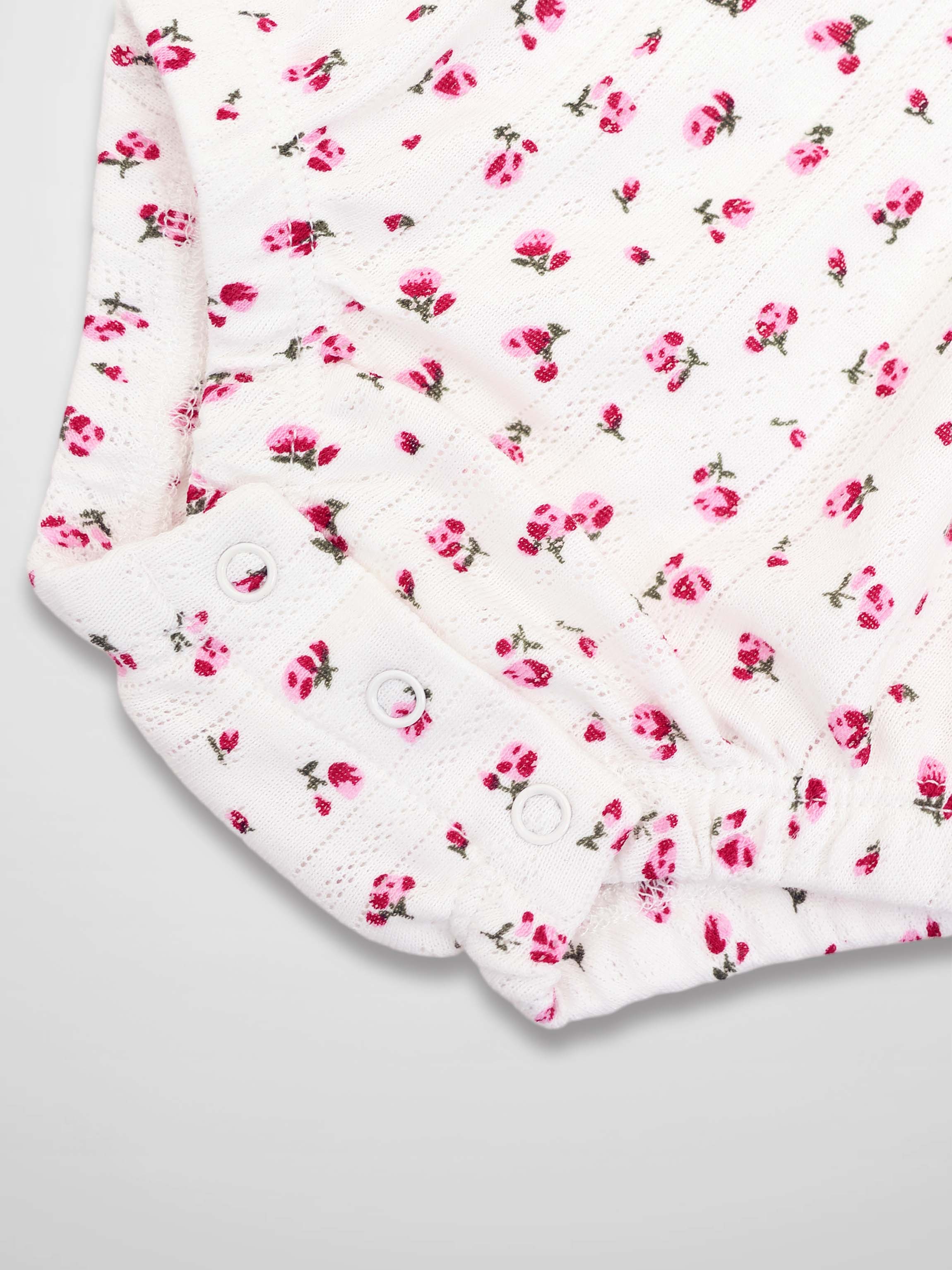 Pointelle Floral Romper for girls in white with pink floral print and snap-button cuffs