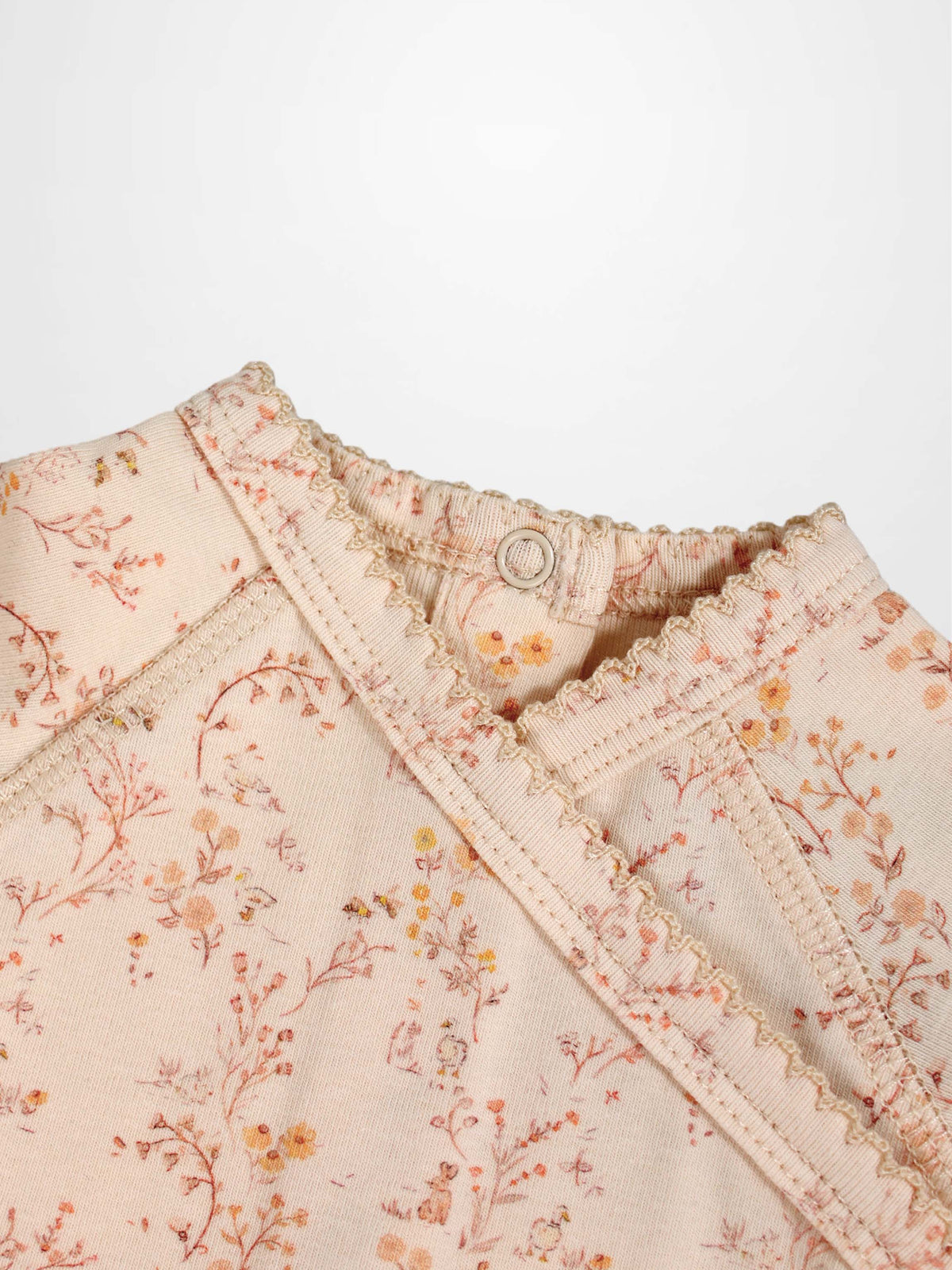 Sweet Meadow Stretchy girls jumpsuit by Adee in light pink floral print with ruffled neckline.