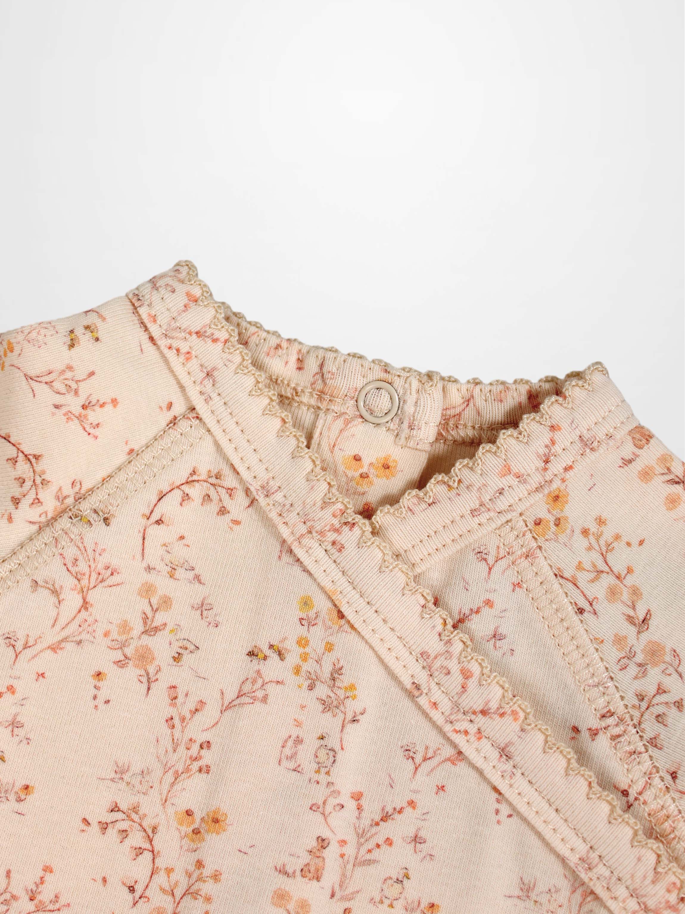 Sweet Meadow Stretchy girls jumpsuit by Adee in light pink floral print with ruffled neckline.