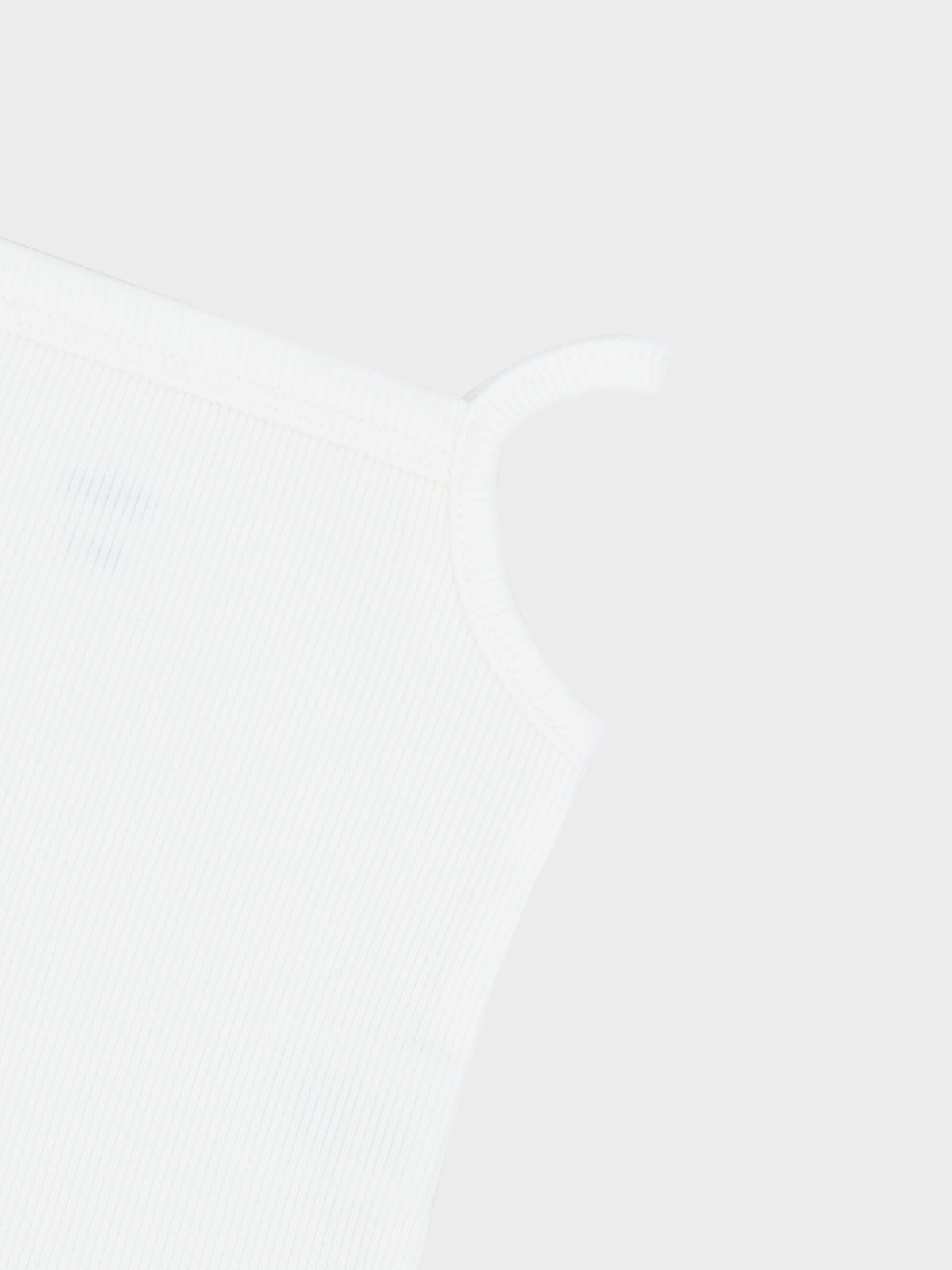 Close-up of a white ribbed undershirt with thin shoulder straps.