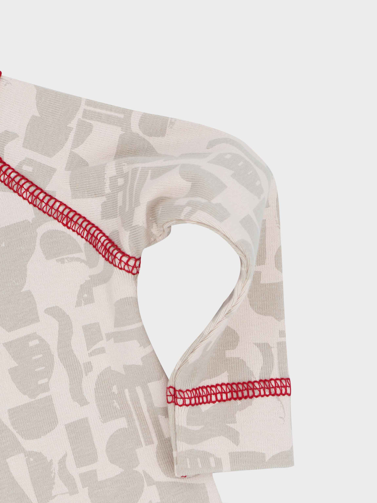 Abstract-print stretchy baby jumpsuit footie with red trim and stitching.