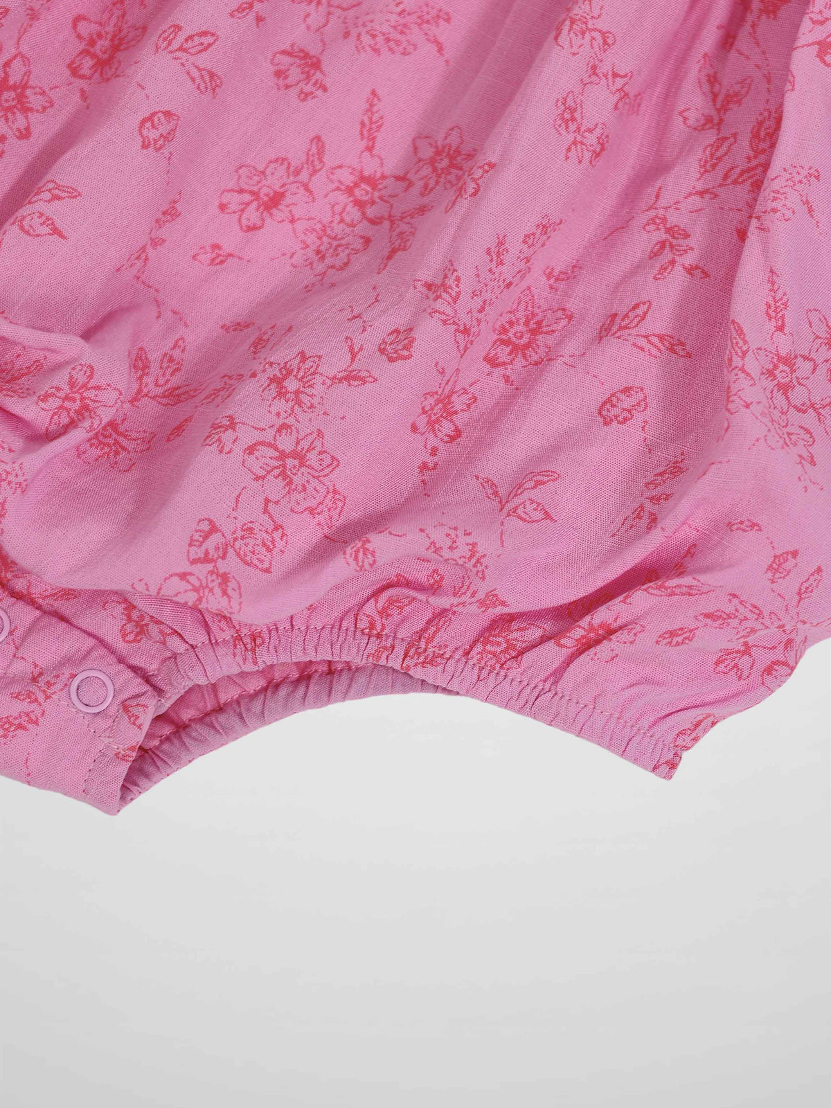 Pink Flower Romper for girls, dressy apparel with pink floral print and elastic leg openings with snap closures.