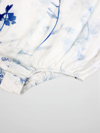 Blue Flower Romper for girls by Adee, dressy white fabric with blue floral print and snap closures.