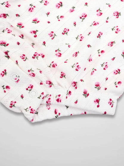 Pointelle floral romper, white with pink blossoms, snap closures.