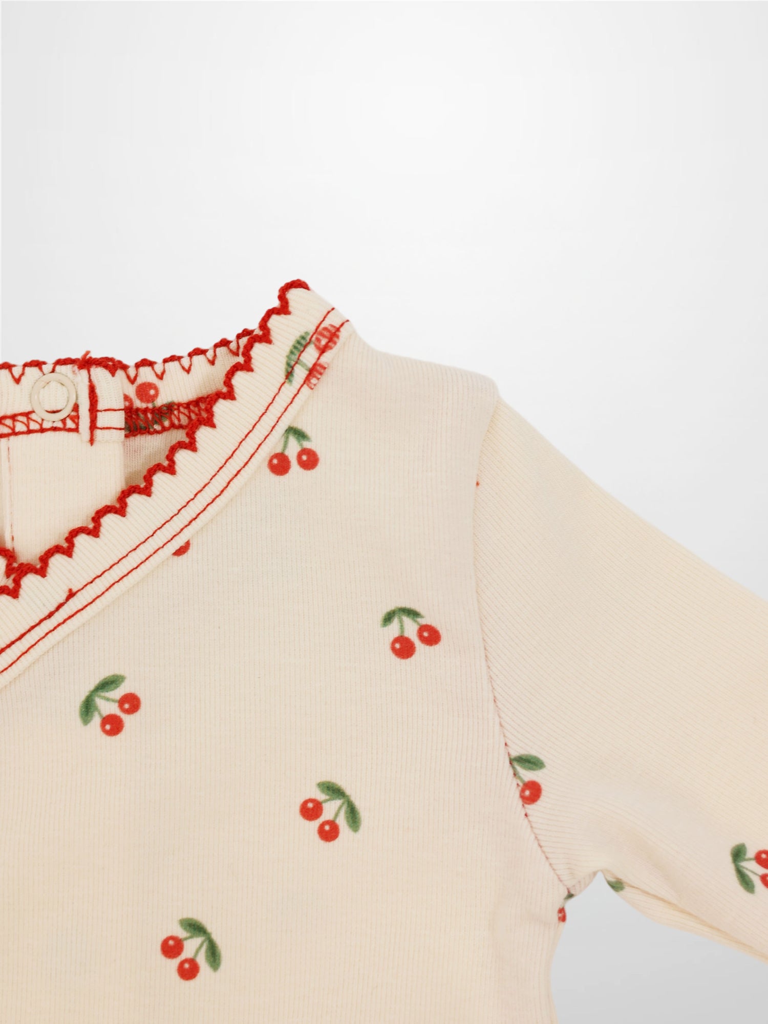 Red Cherry Stretchy girls top by Adee with cherry print on cream knit and green leaves
