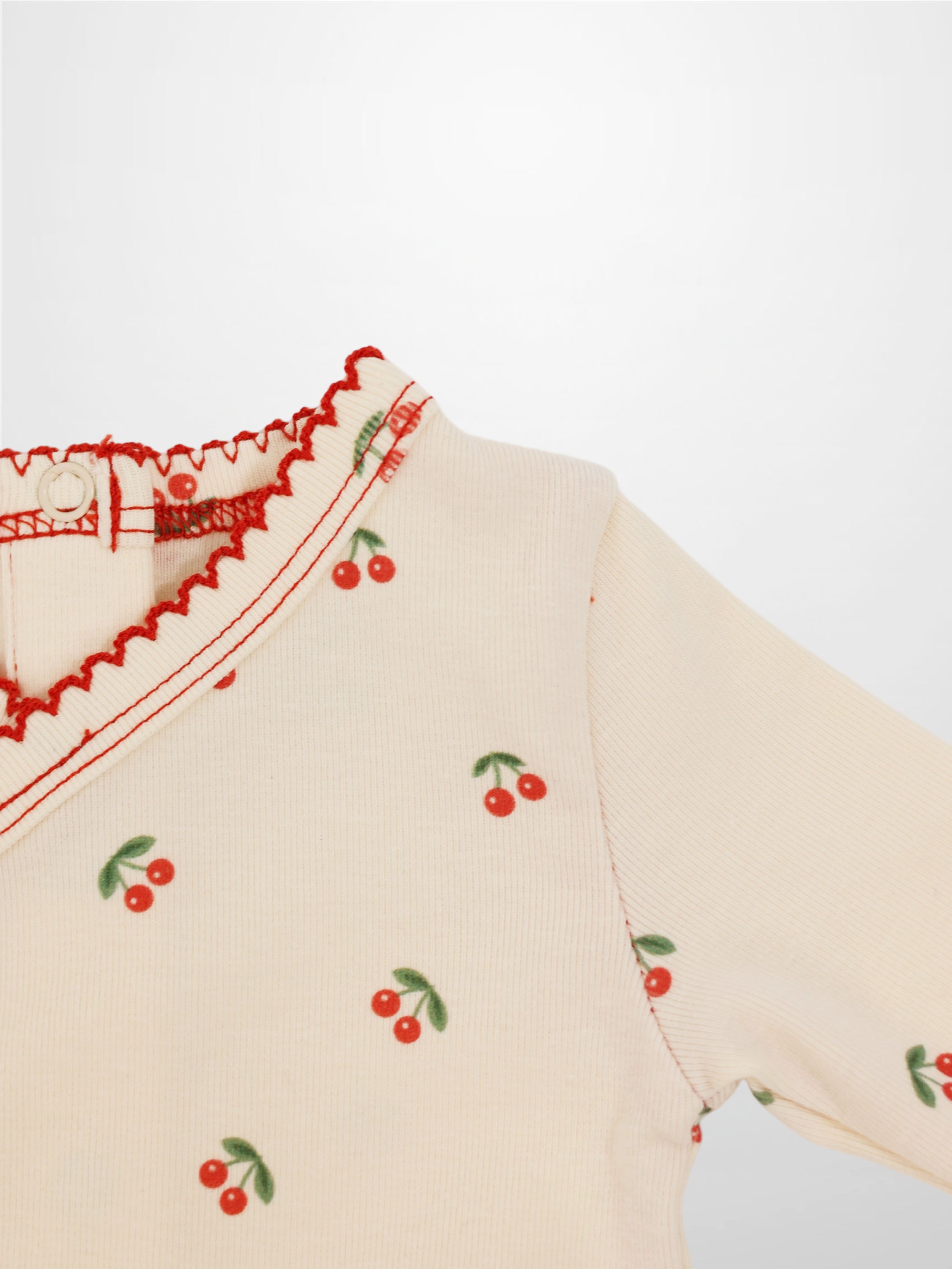 Red Cherry Stretchy girls top by Adee with cherry print on cream knit and green leaves
