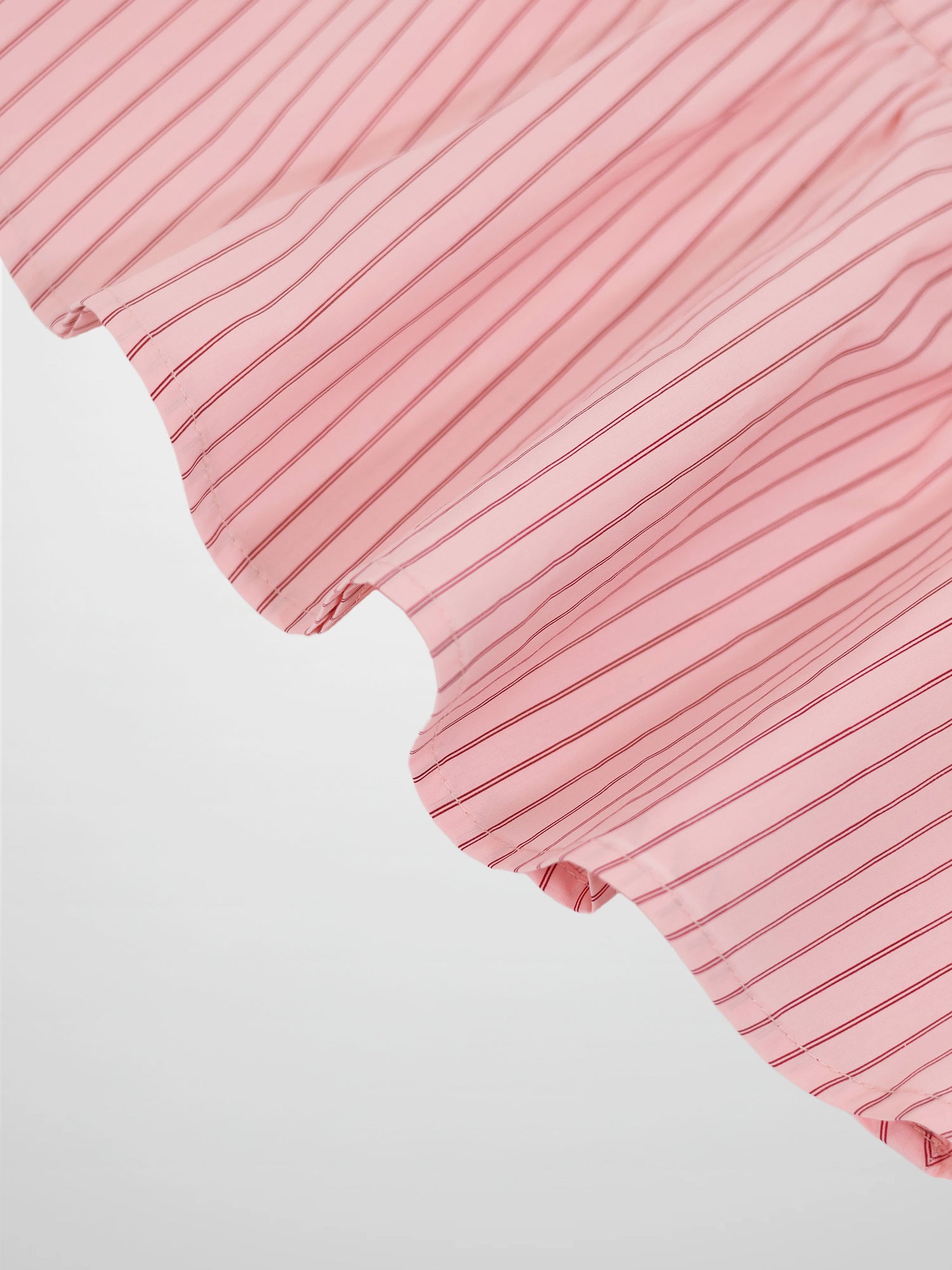 Pink striped cotton skirt with curved hem detail.