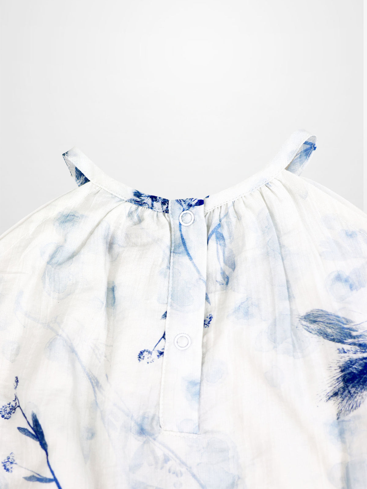 Blue Flower Jumper dress by Adee; white fabric with blue floral print and back neck button detail.