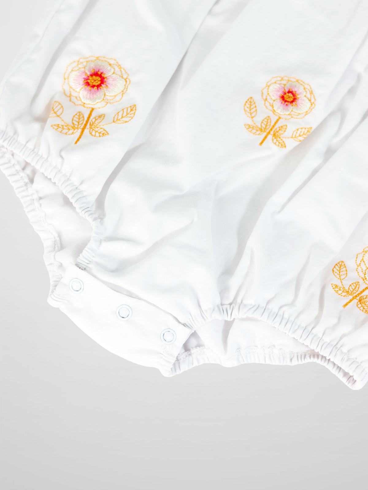 Embroidered Flower Romper by Adee, white girls dressy romper with orange floral embroidery and elastic cuffs.