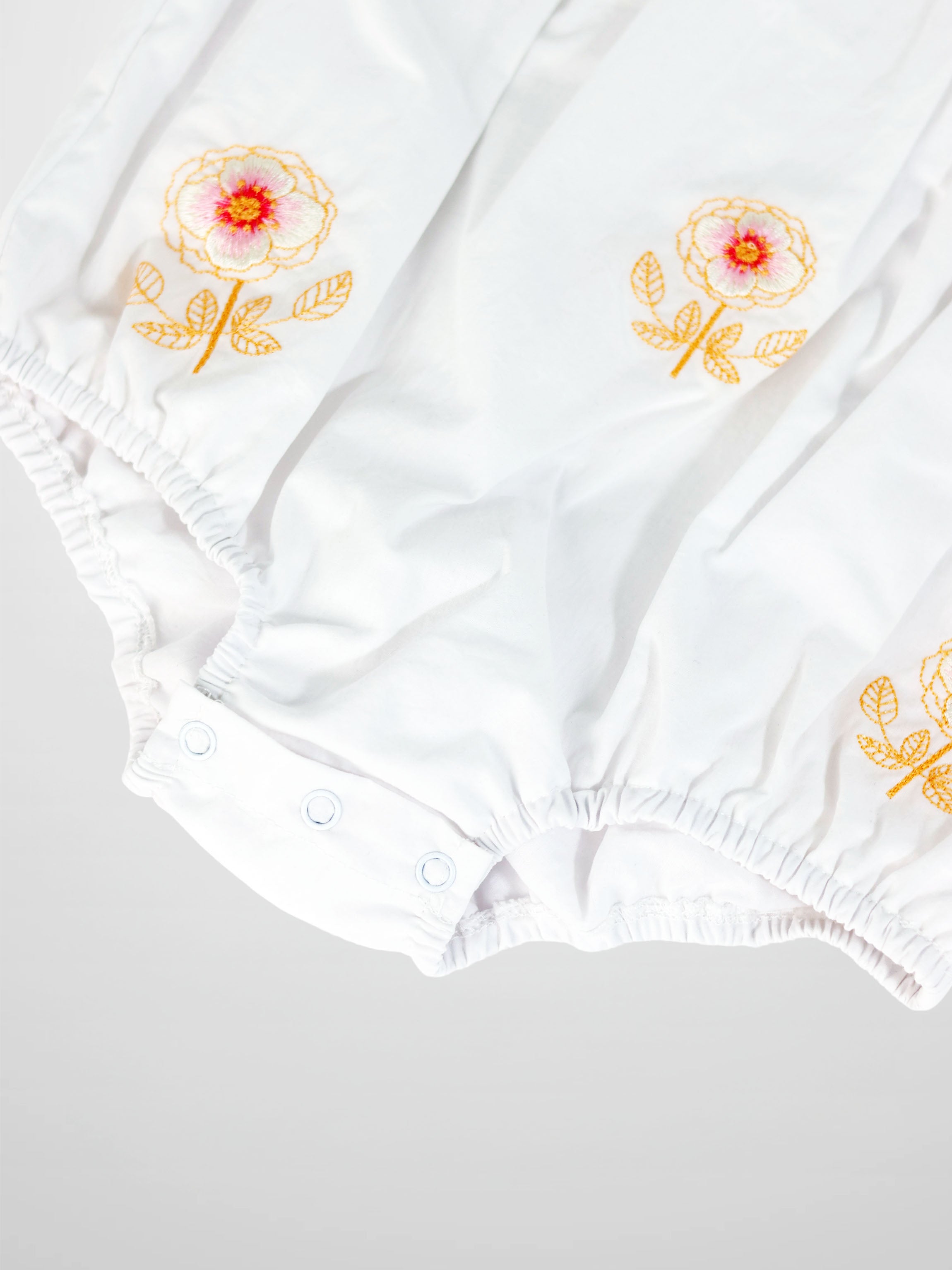 Embroidered Flower Romper by Adee, white girls dressy romper with orange floral embroidery and elastic cuffs.