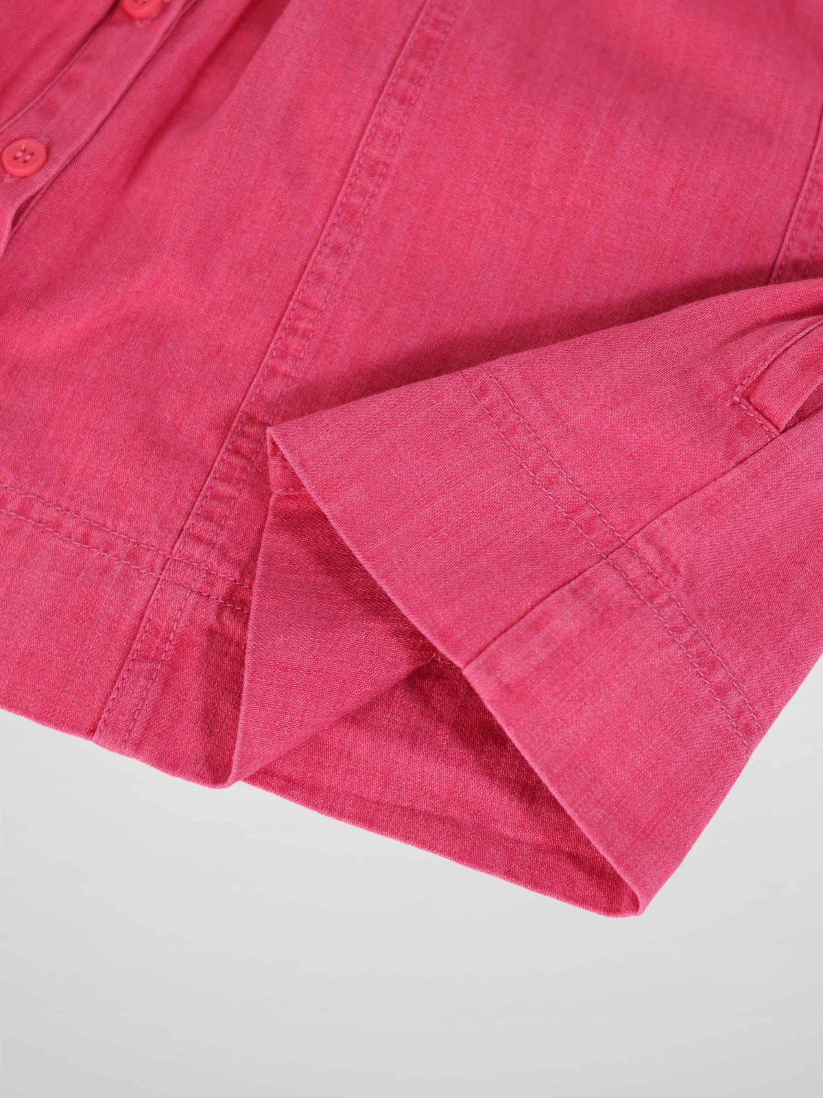 Close-up of pink denim 3/4 sleeve dress, showing cuff and button placket.