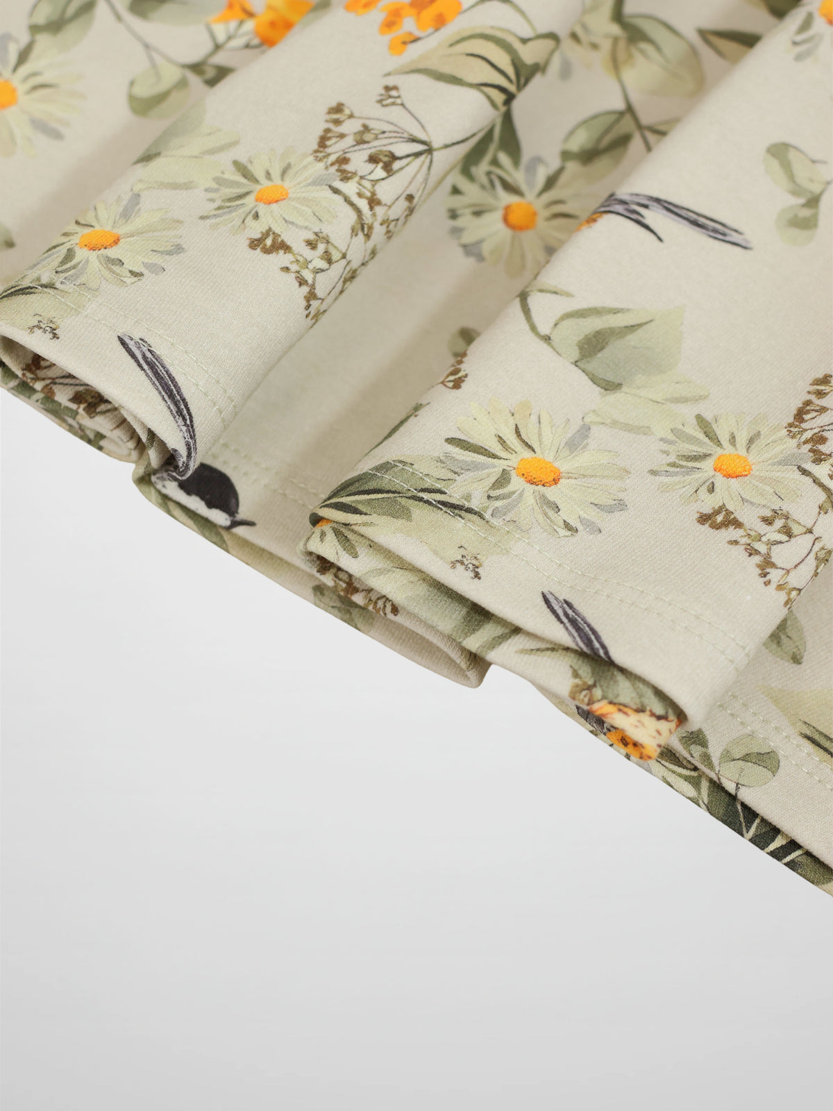 Garden Finch Circle Skirt for girls; light beige floral print with white daisies and orange centers.