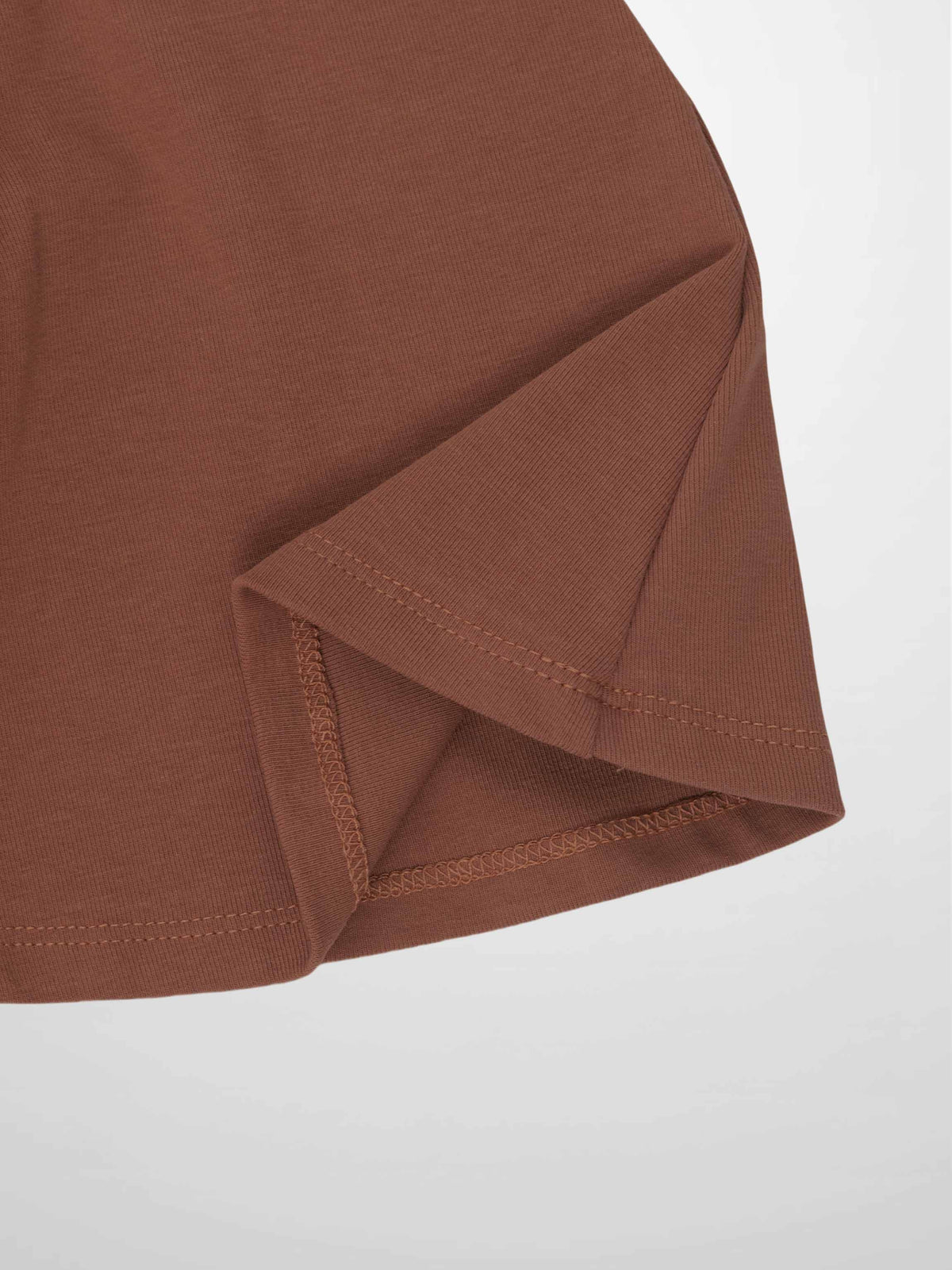 Dark mauve six-panel skirt close-up showing hem stitching and panel seam.