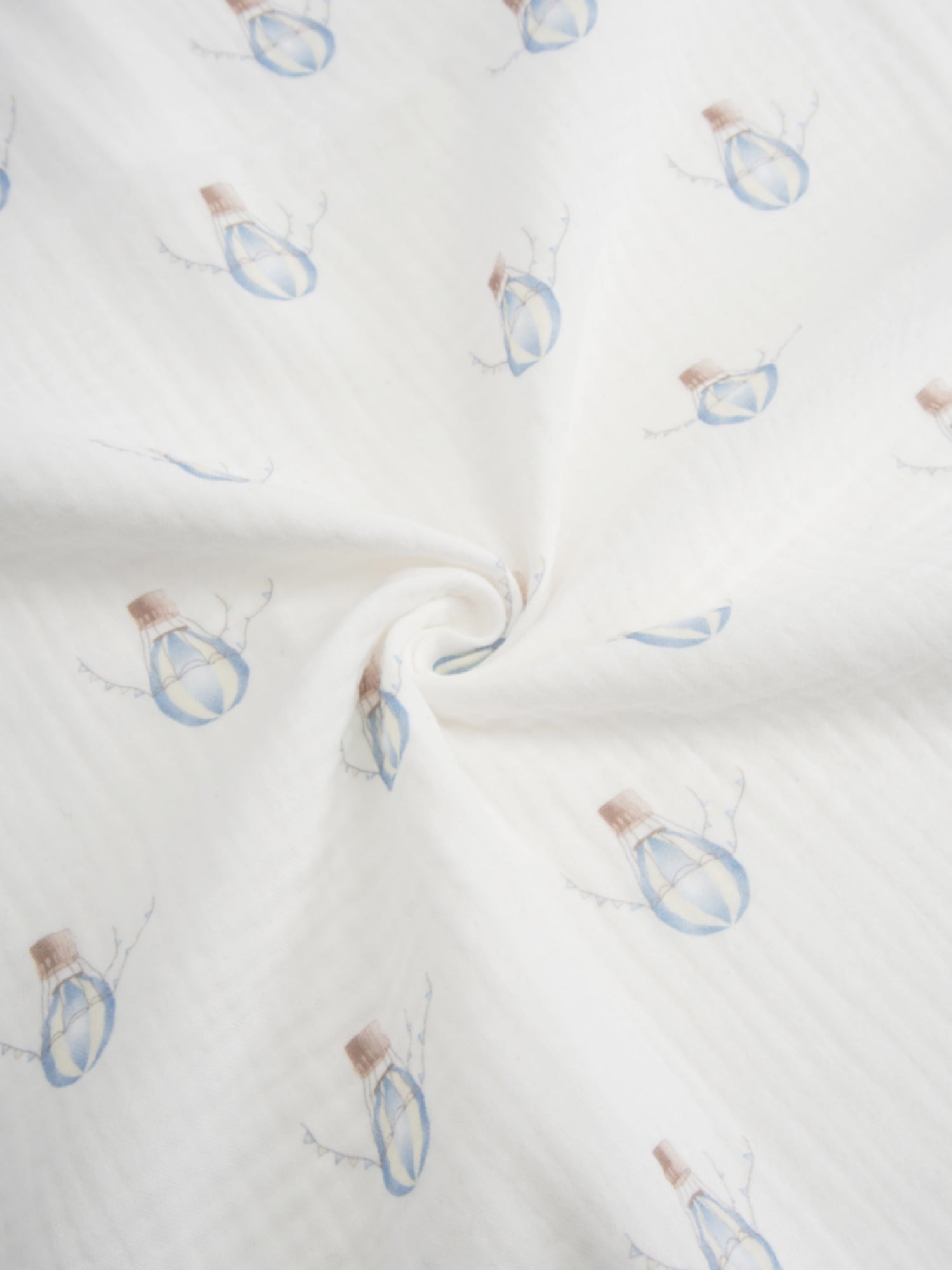 Blue balloon swaddle blanket on white fabric with light blue balloon prints