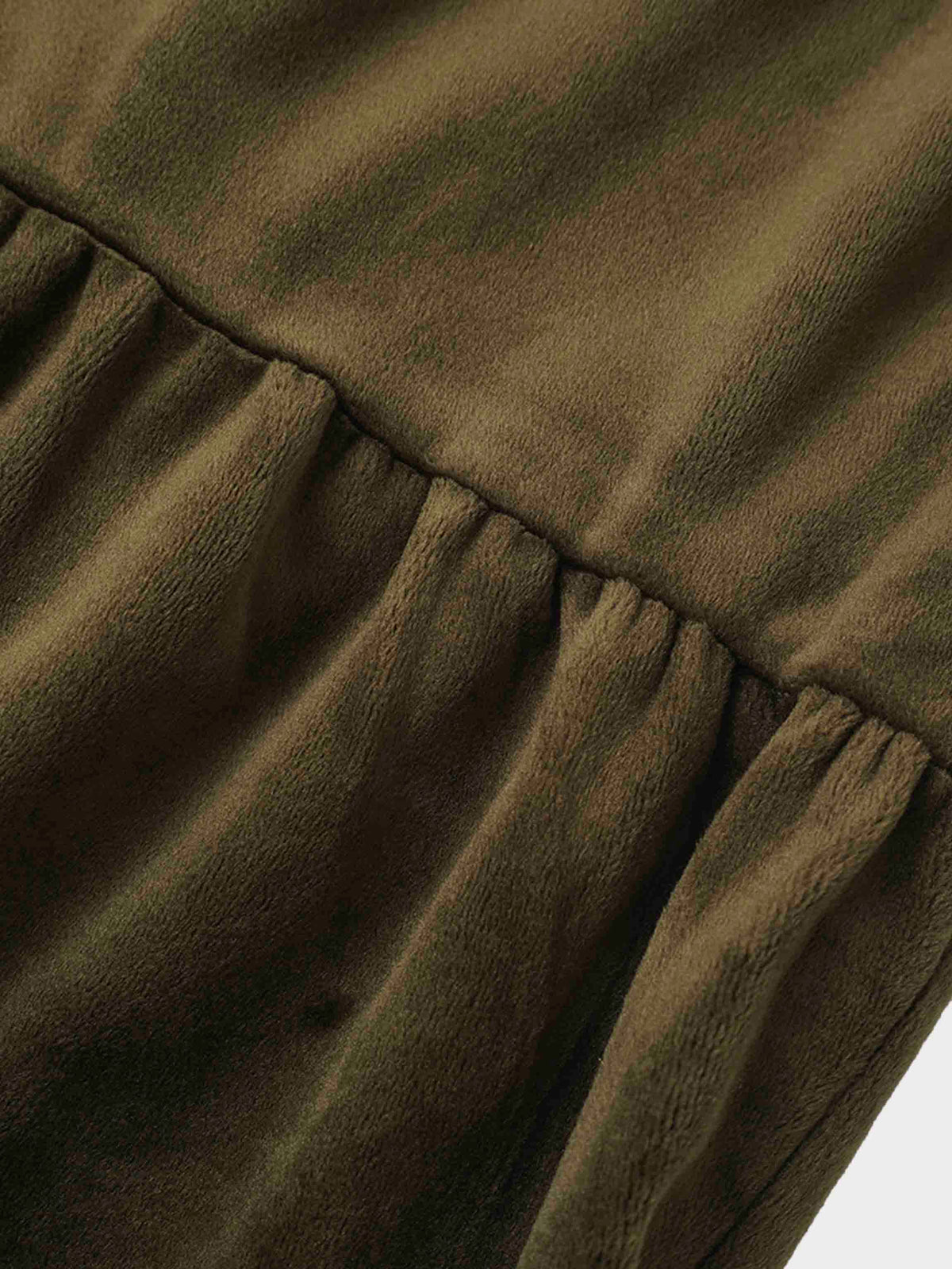 Hunter green velour fabric close up with tiered gathers and plush texture.