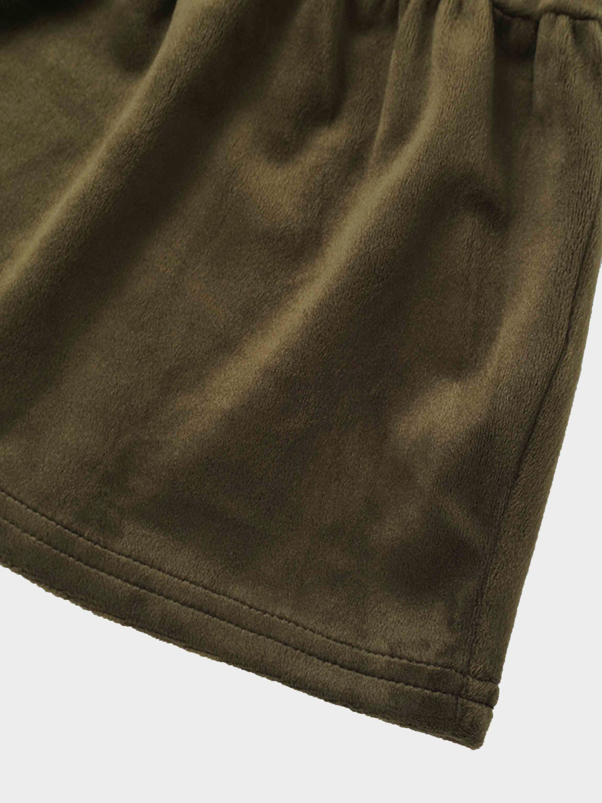 Hunter green velour robe hem with plush fabric and double-stitched edge.