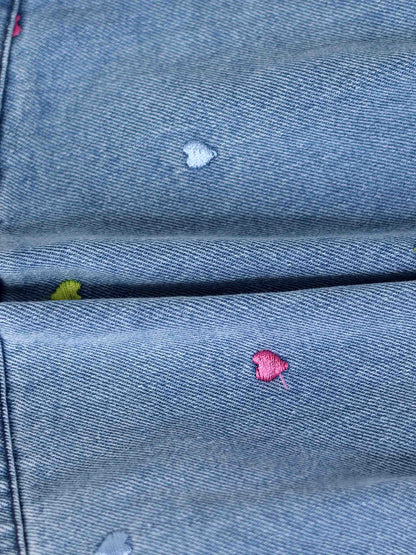 Blue denim fabric with small multicolor embroidered hearts.