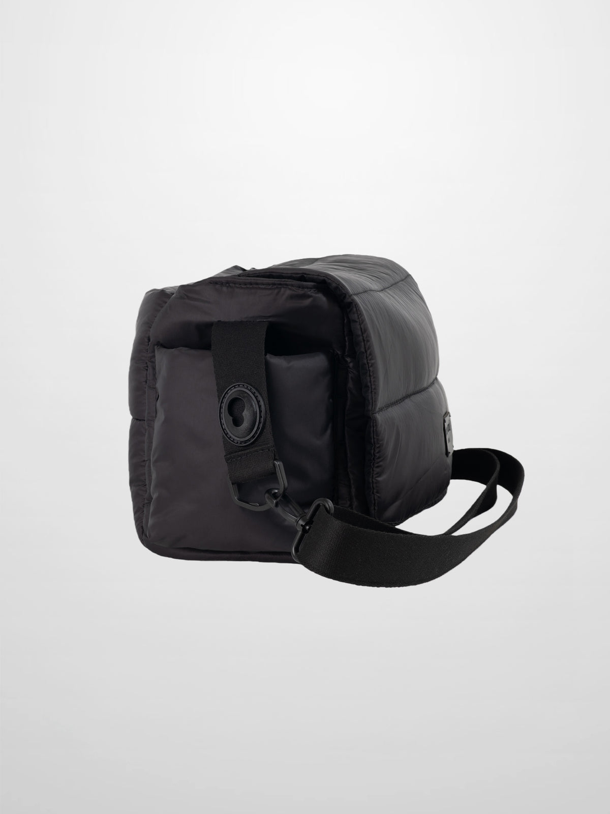 Diaper bag in sleek black padded fabric with a foldover design and adjustable shoulder strap.