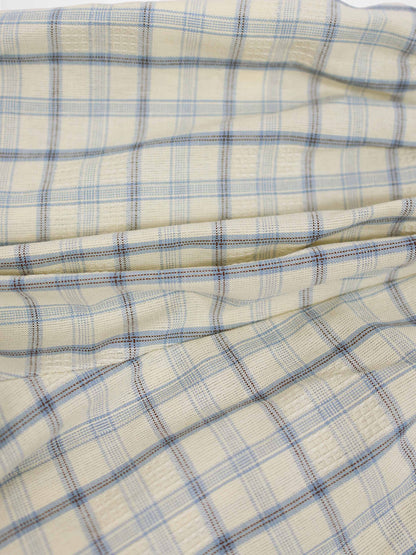 Cream plaid fabric for shorts with light blue and brown lines, soft woven texture.
