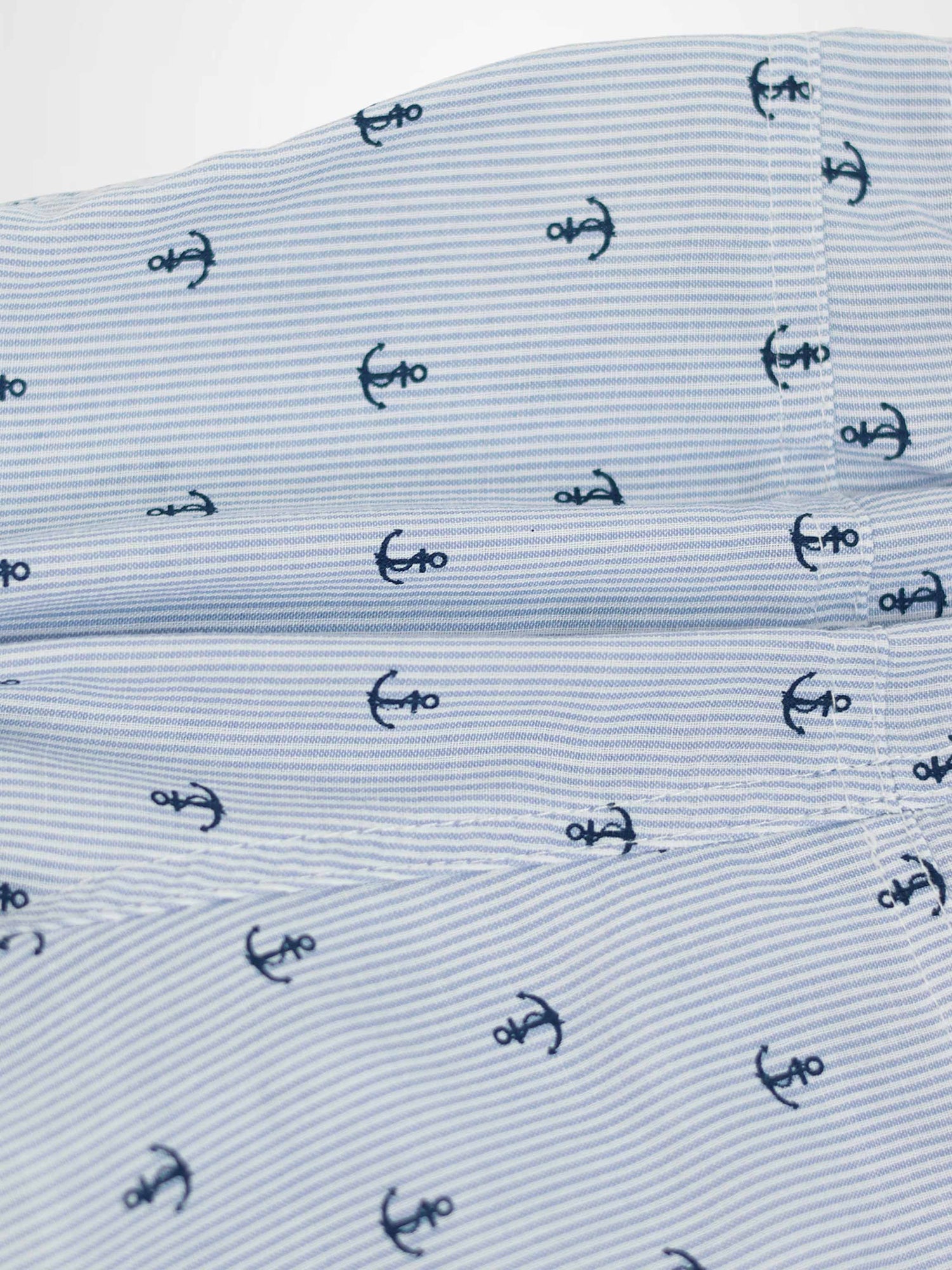 Anchor Shorts fabric close-up with narrow blue stripes and scattered navy anchor motifs.