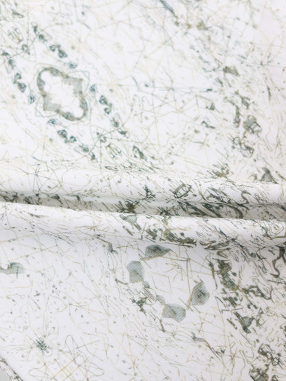 Map T-shirt fabric with fine sage-green lines, compass markers, and vintage geography print on off-white fabric.