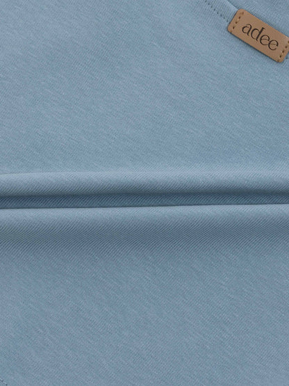 Light blue baseball T-shirt fabric with a tan leather tag reading adee.