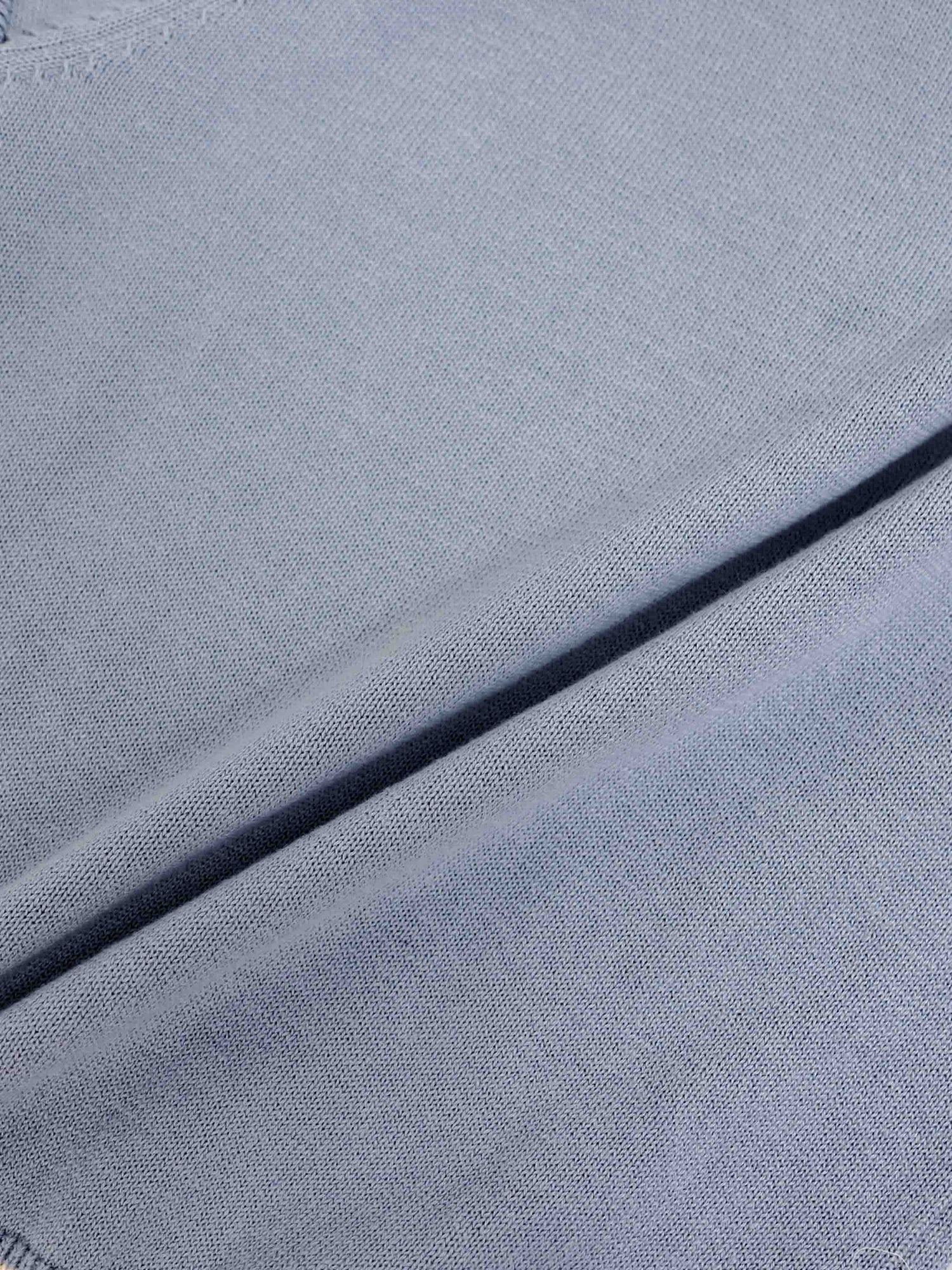 Light blue knit sweater fabric close-up with soft, fine texture.