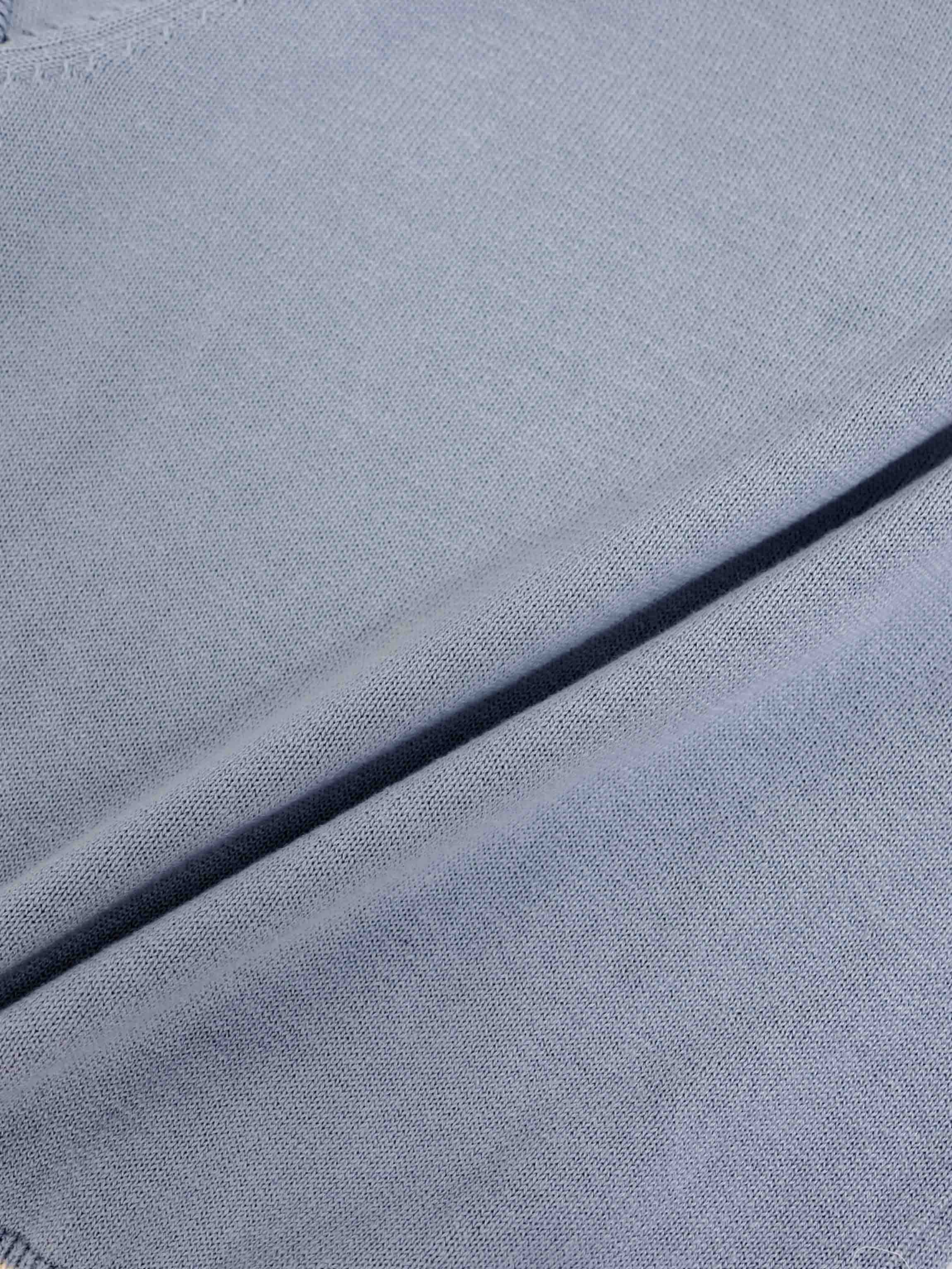 Light blue knit sweater fabric close-up with soft, fine texture.