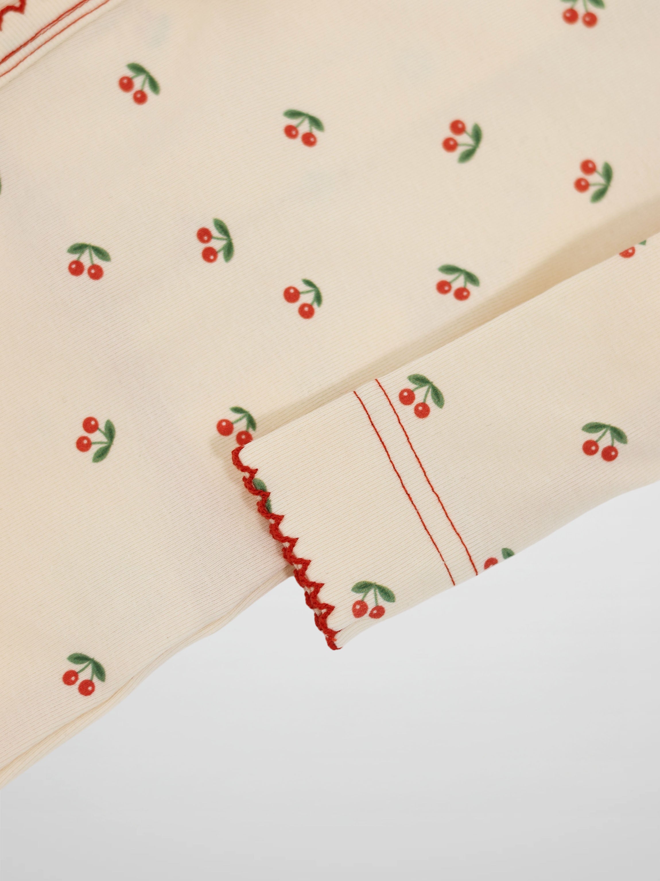 Red Cherry Stretchy girls stretchies with bright red cherries on green fabric