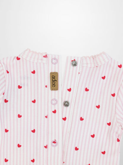 Back view of light pink and white striped baby jumpsuit with red hearts, back snaps, and scalloped trim.
