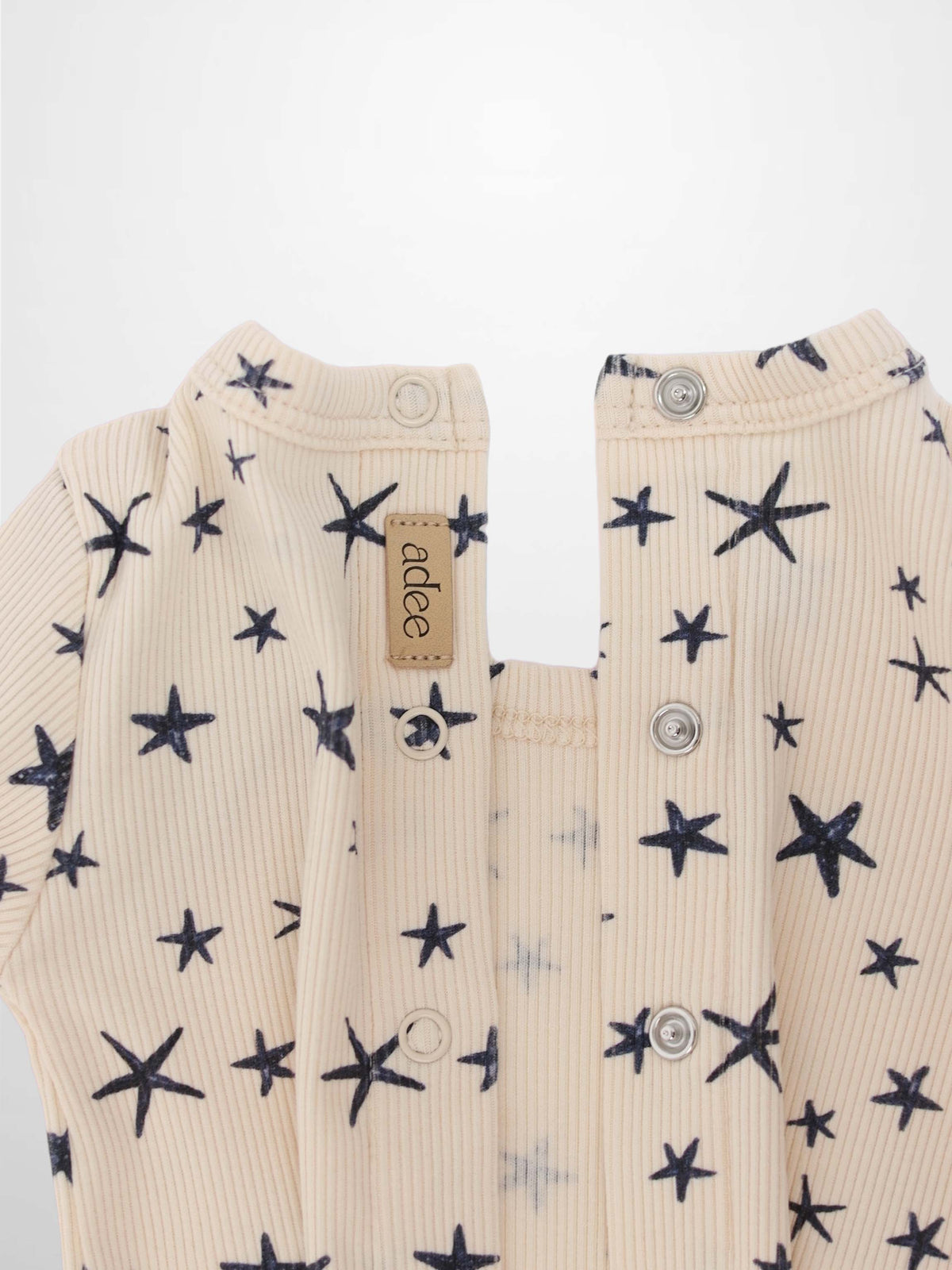 Star Stretchy boys stretchies by Adee in light beige ribbed fabric with navy star pattern; front snaps.