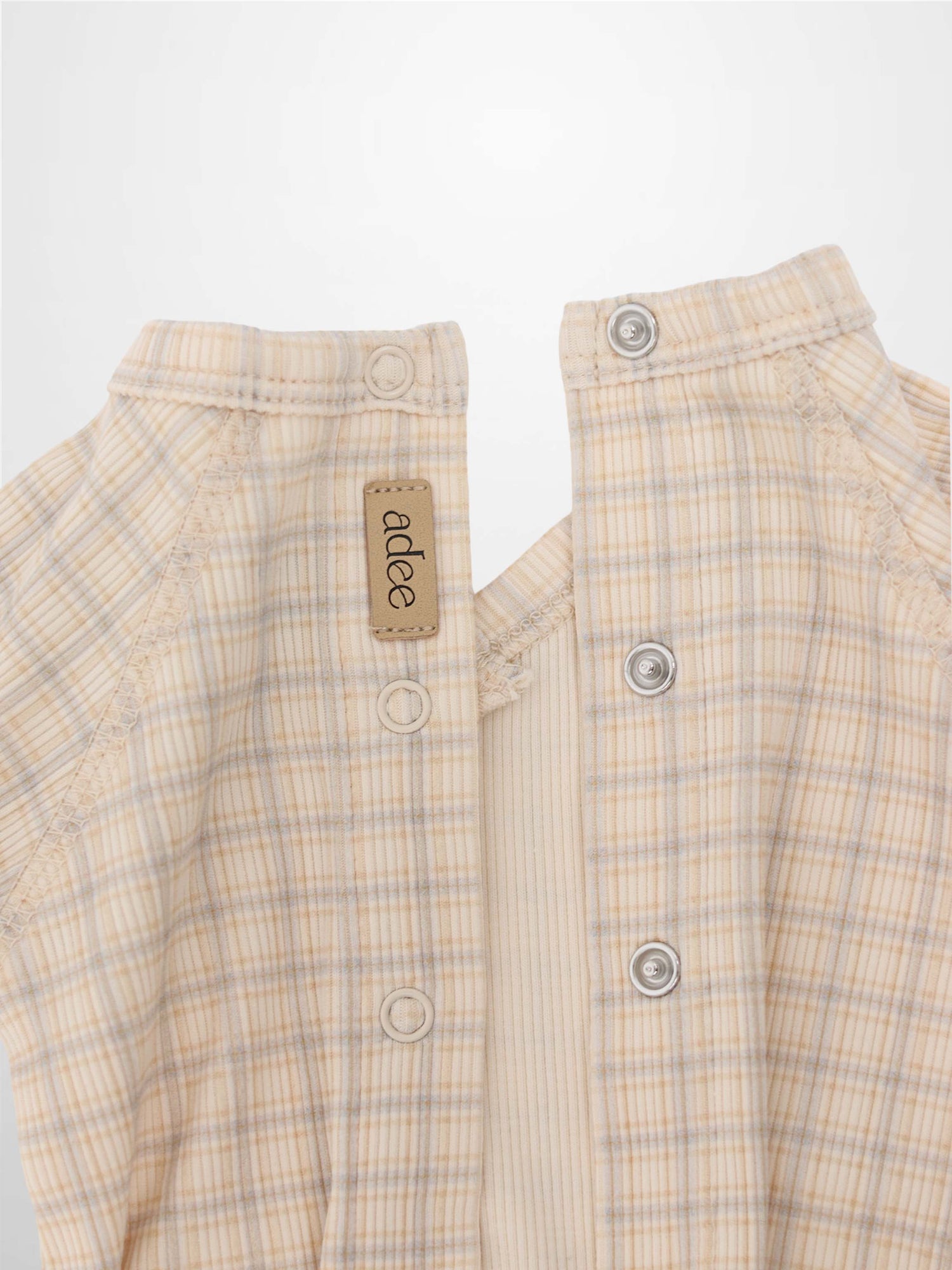 Oatmeal grid-stretchy baby jumpsuit footie with light blue and brown plaid; front snaps.