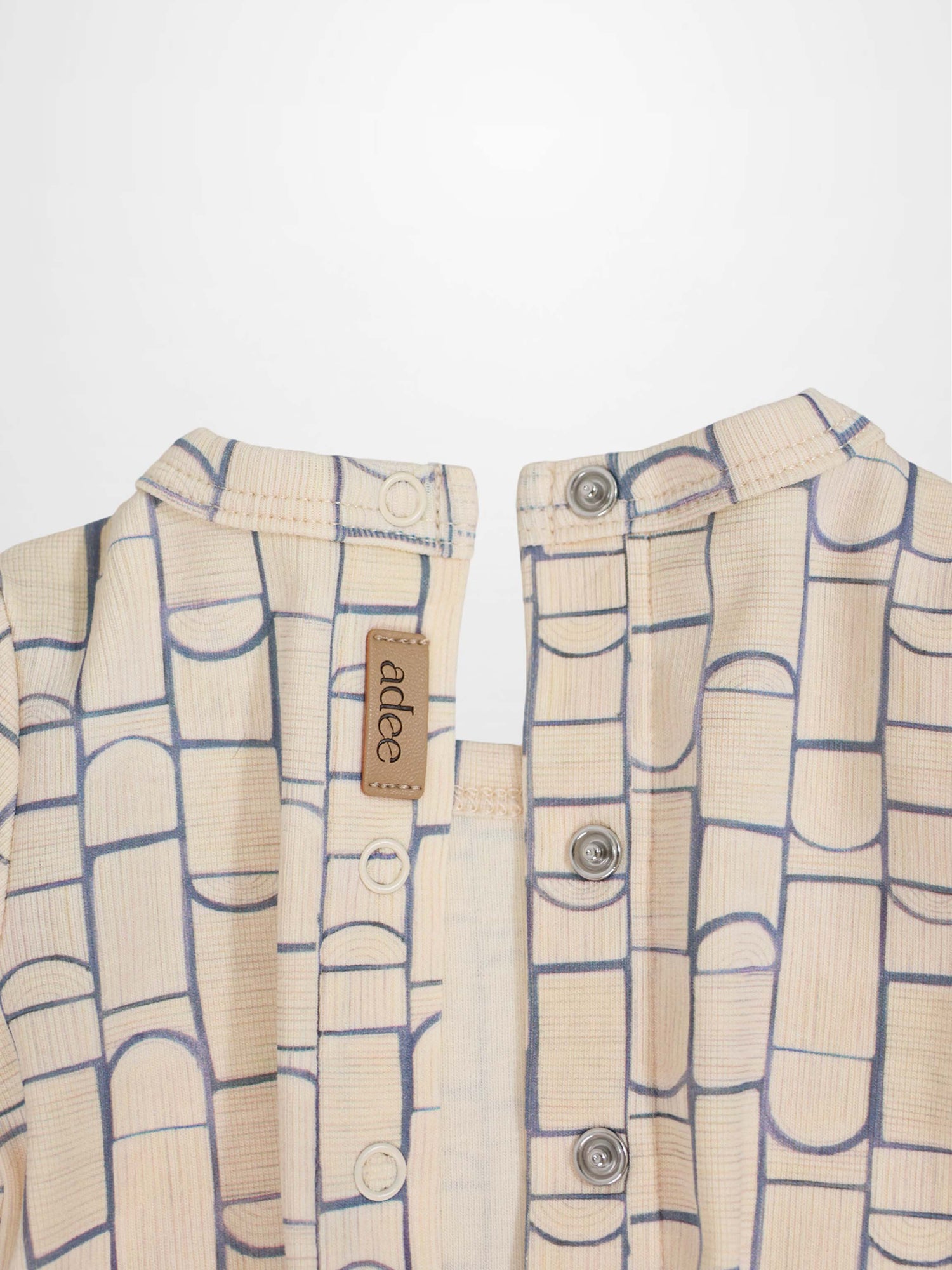 Geometric Crossover Stretchy baby jumpsuit: beige with light-blue rounded-rectangle pattern and crossover front.