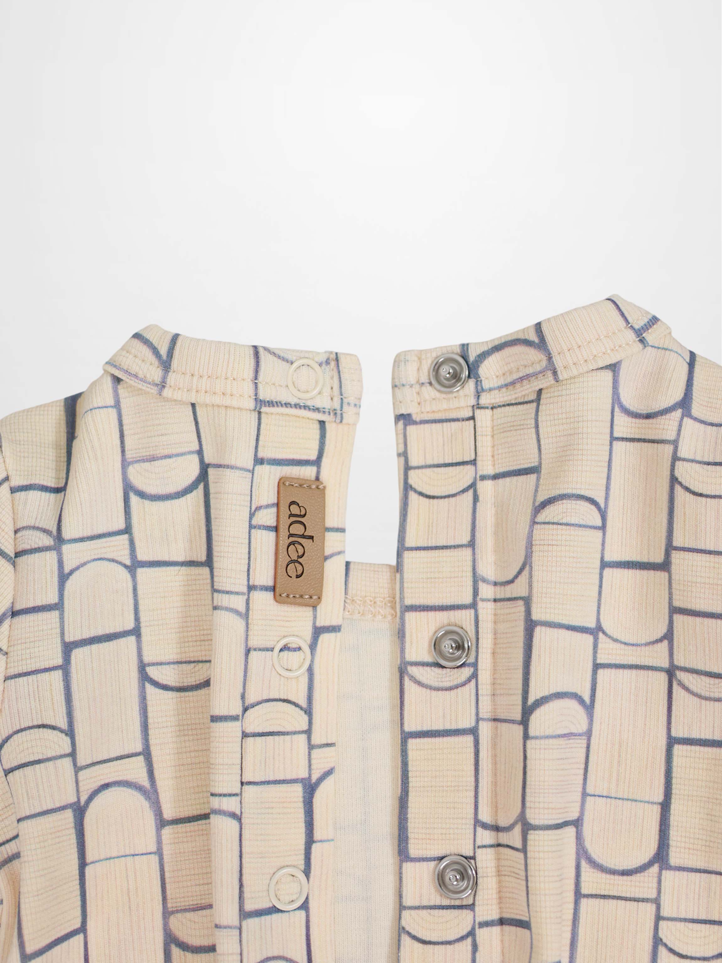 Geometric Crossover Stretchy baby jumpsuit: beige with light-blue rounded-rectangle pattern and crossover front.