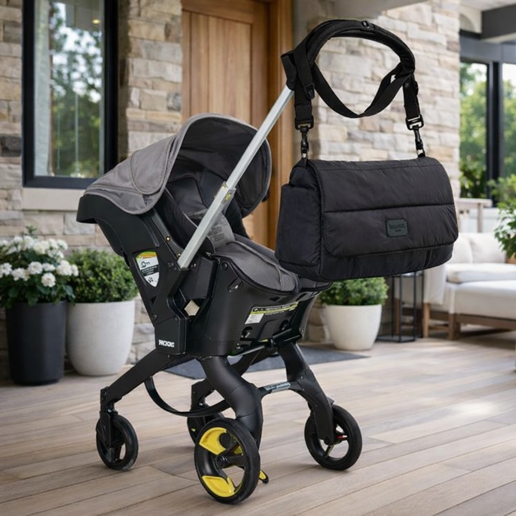 Black padded foldover diaper bag attached to stroller handle, a stylish, practical carry solution for modern parents.