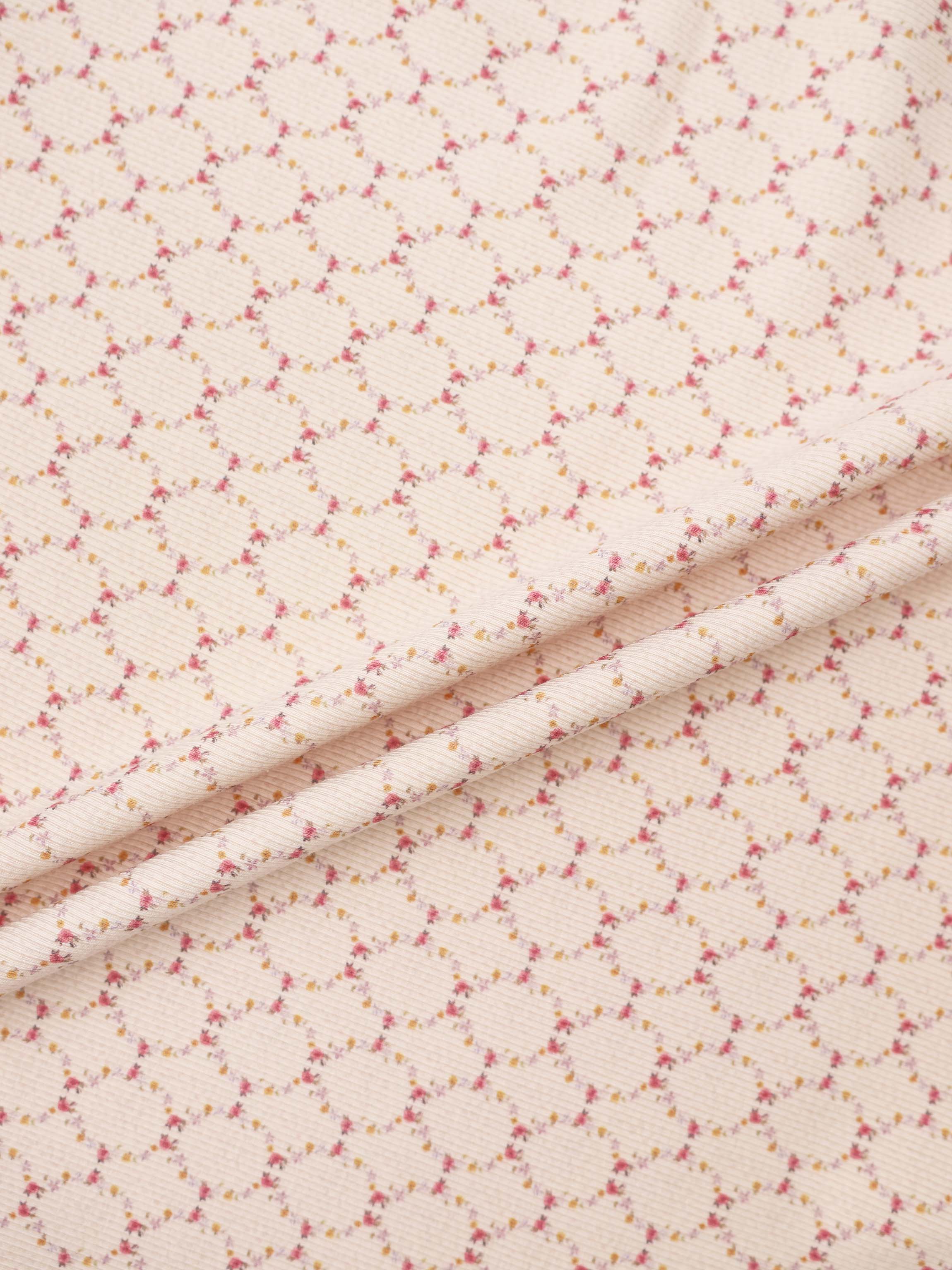 Floral Garland Stretchy girls fabric in pale pink with tiny pink and yellow florals.