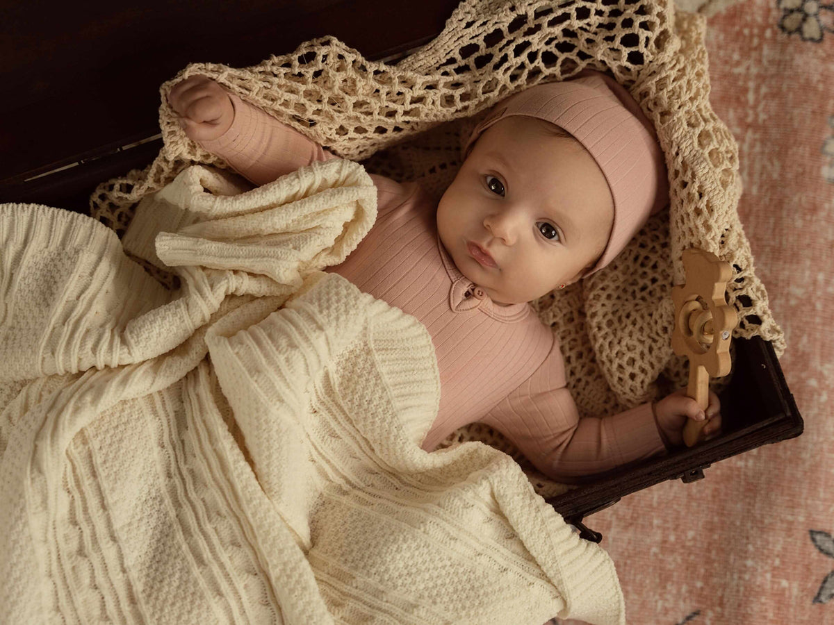 Wide Ribbed Beanie Pink for girls by Adee, worn by a baby in a cream knit blanket.